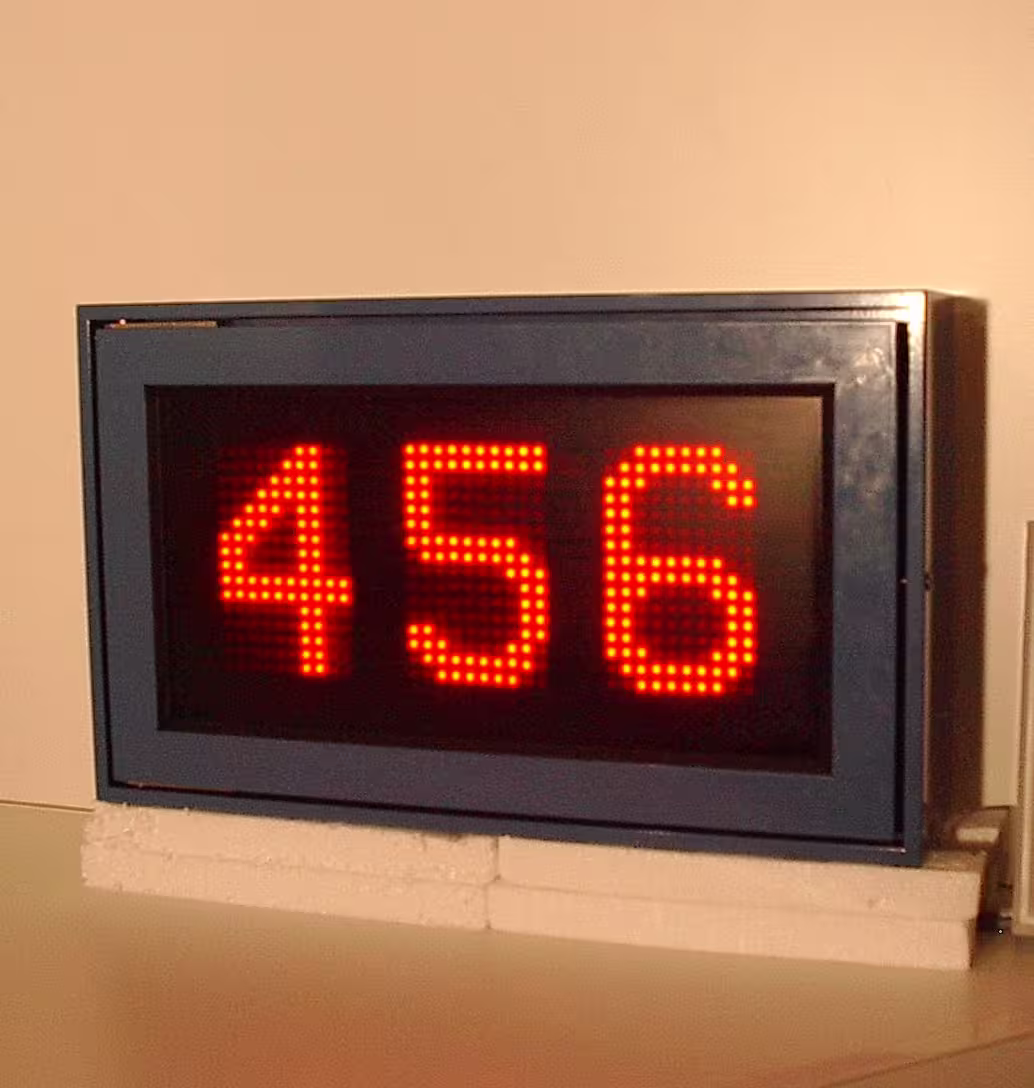 Anzeigegehäuse auf einem Tisch zeigt die dreistellige rote LED-Ziffernfolge 456