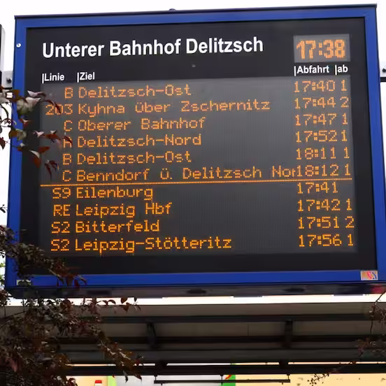 Large departure board Unterer Bahnhof Delitzsch with the time and orange line and destination details