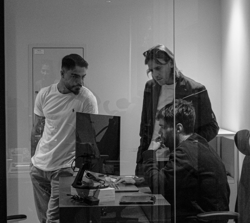 Black-and-white aerial view of a dense cluster of modern skyscrapers in a city skyline.