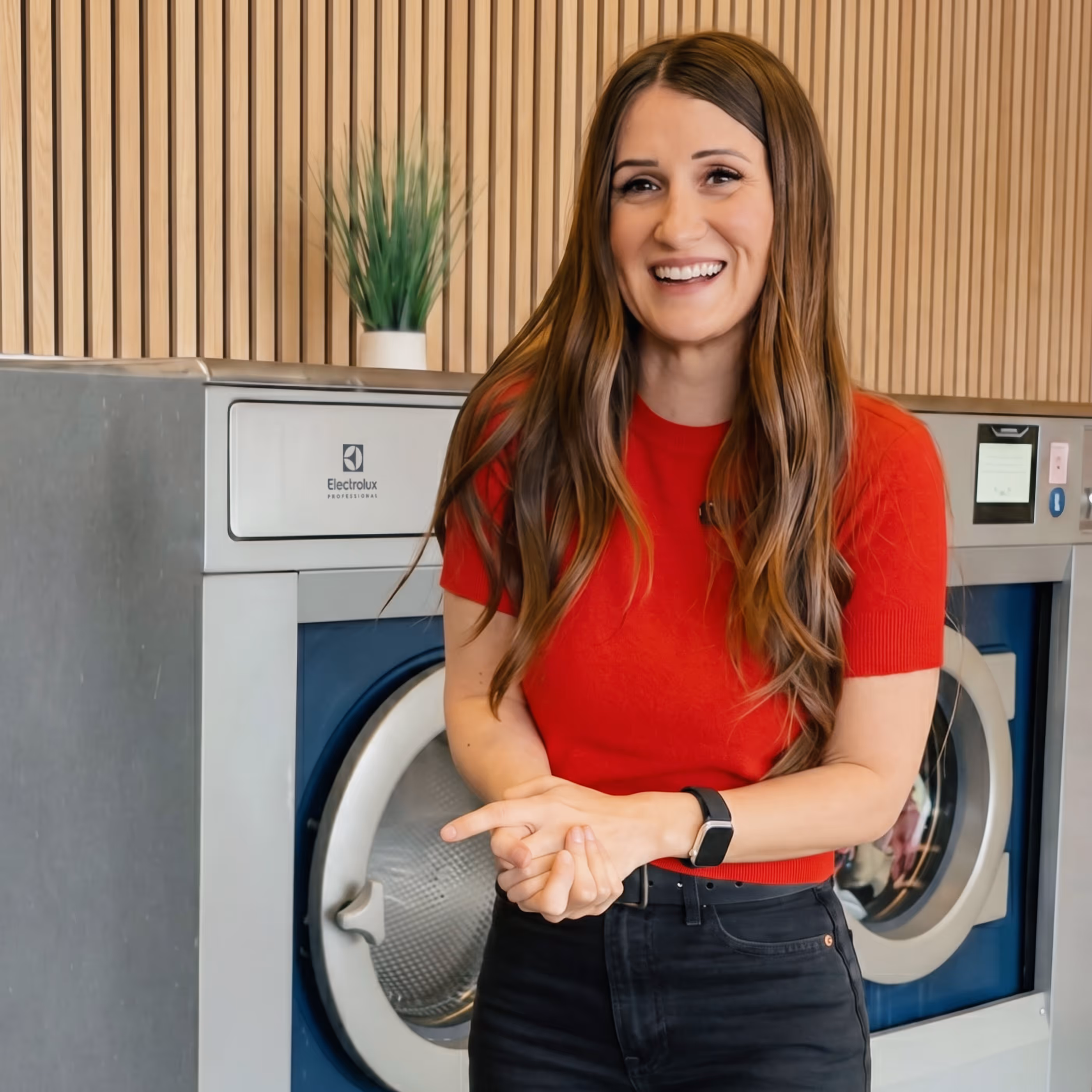 Laundromat Girl standing next to high-spin Electrolux Professional washing machines in a newly built laundromat