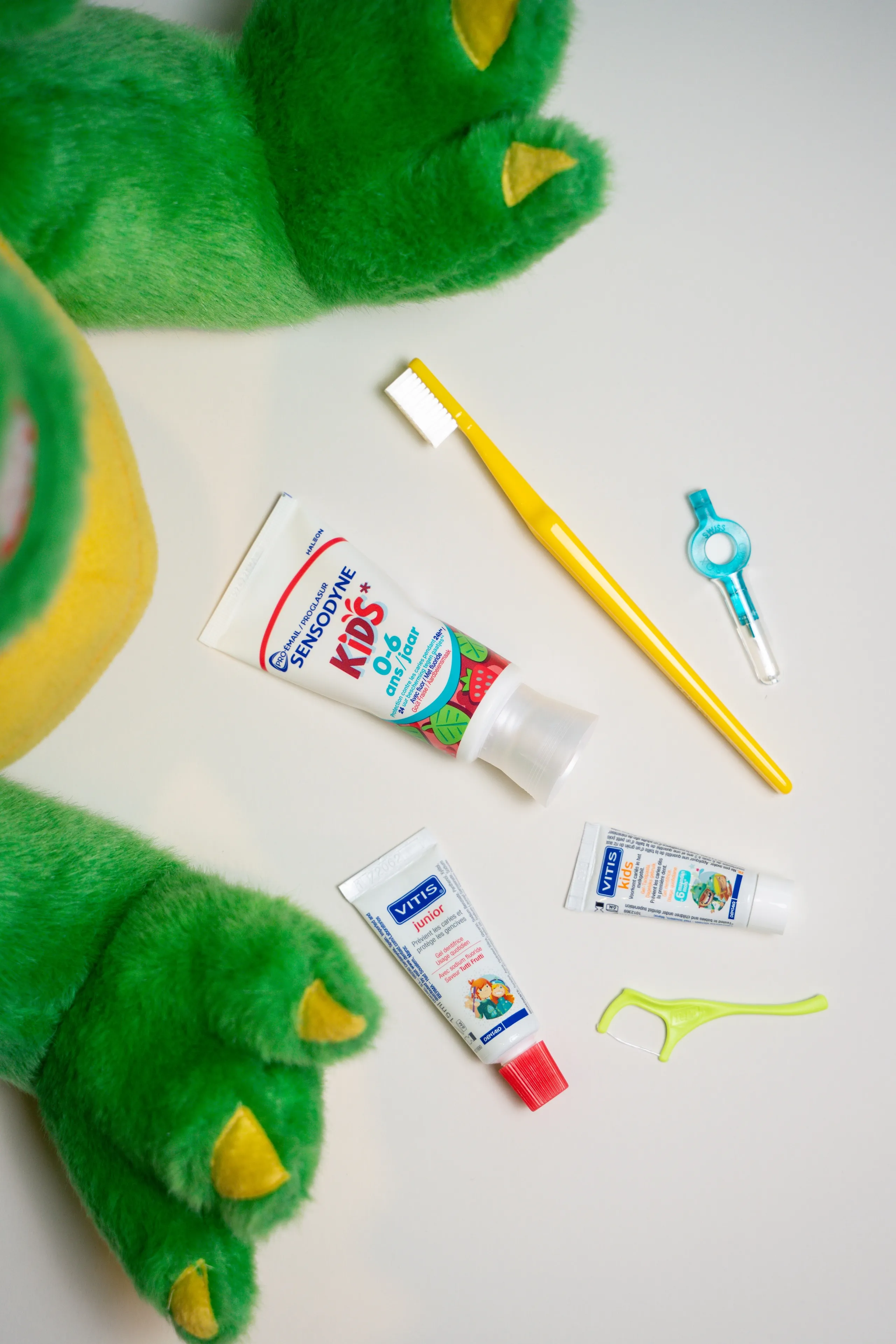 Novi met kindertandpasta, tandenborstel en flosdraad op.