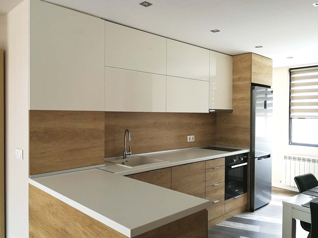 Ъглова кухня с бар плот: EGGER H3331 ST10 Дъб Небраска Натур и PerfectSense гланц W1000, бял плот GETALIT, гръб H3331 ST10, механизми Blum с плавно затваряне.