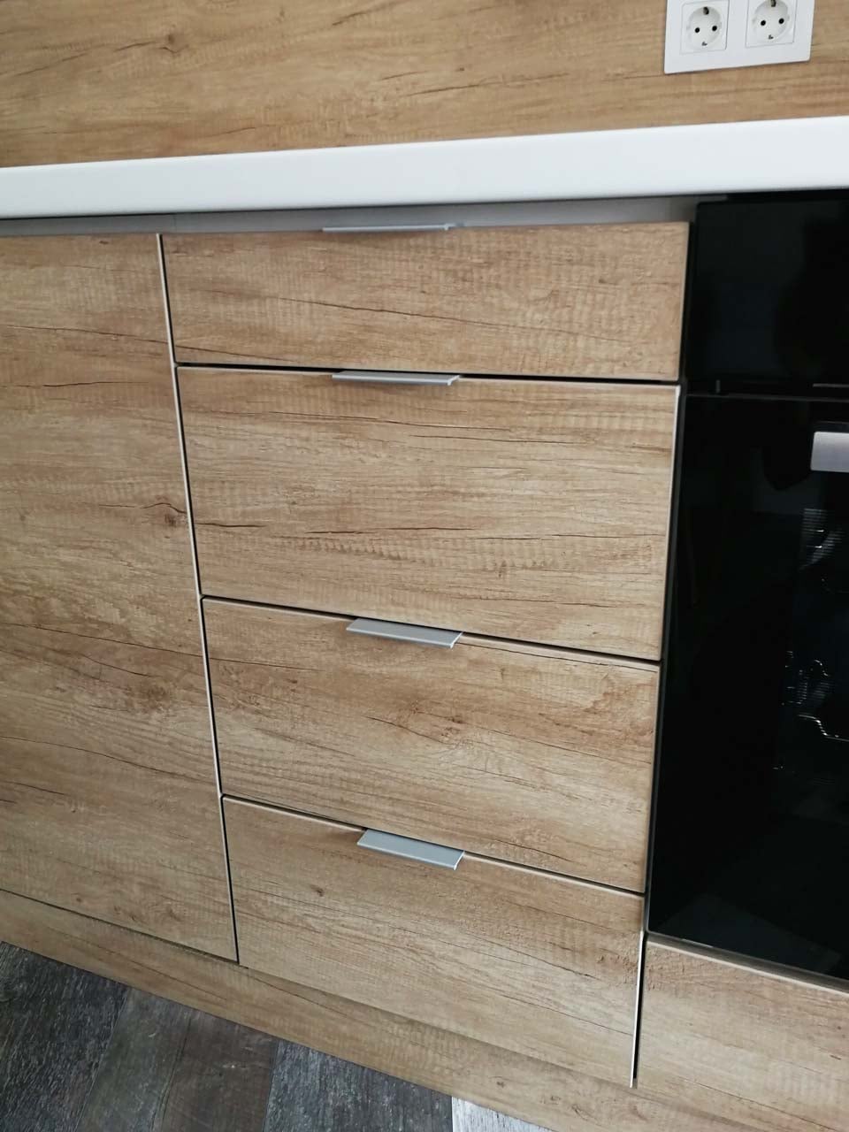 Детайл на чекмеджета до фурна; лице H3331 ST10 Дъб Небраска, плот бял GETALIT, плавно затваряне Blum.