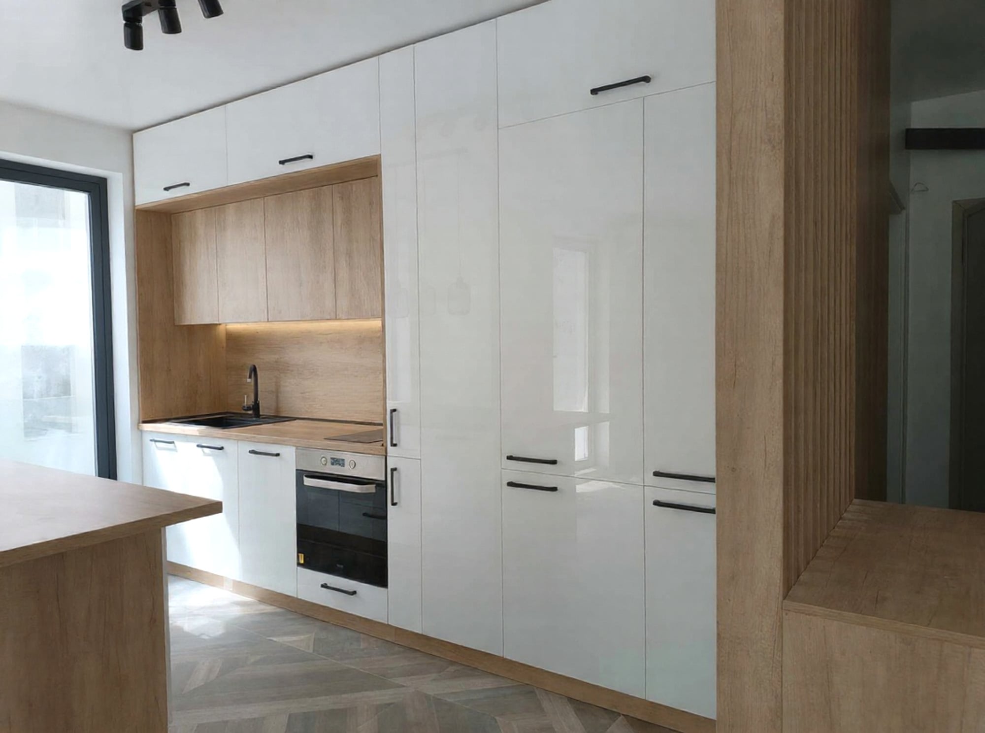 Вградени кухненски мебели до таван – високи шкафове в алпийско бяло W1100 и работна зона в дървесен декор