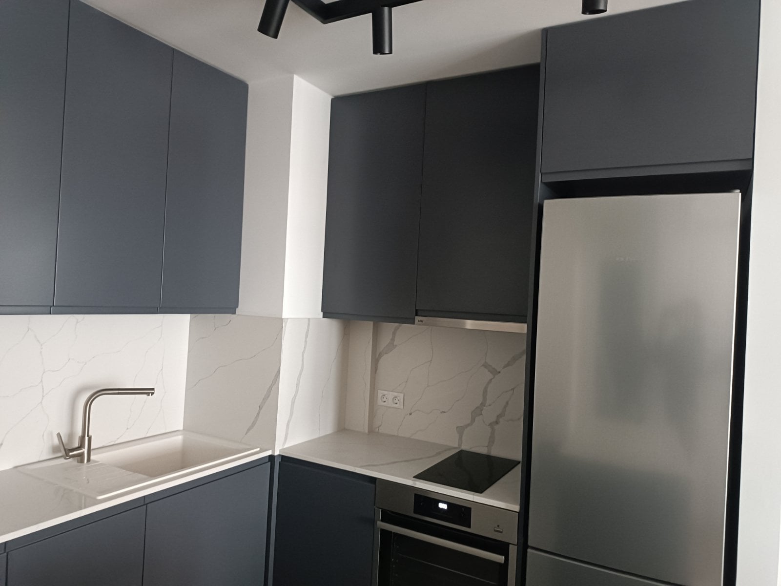 Ъгъл при готвене с плот и гръб Crystal Calacatta Amnis TECHNISTONE (технически камък) и матови фронтове RAL 7043, вградена фурна, Blum.