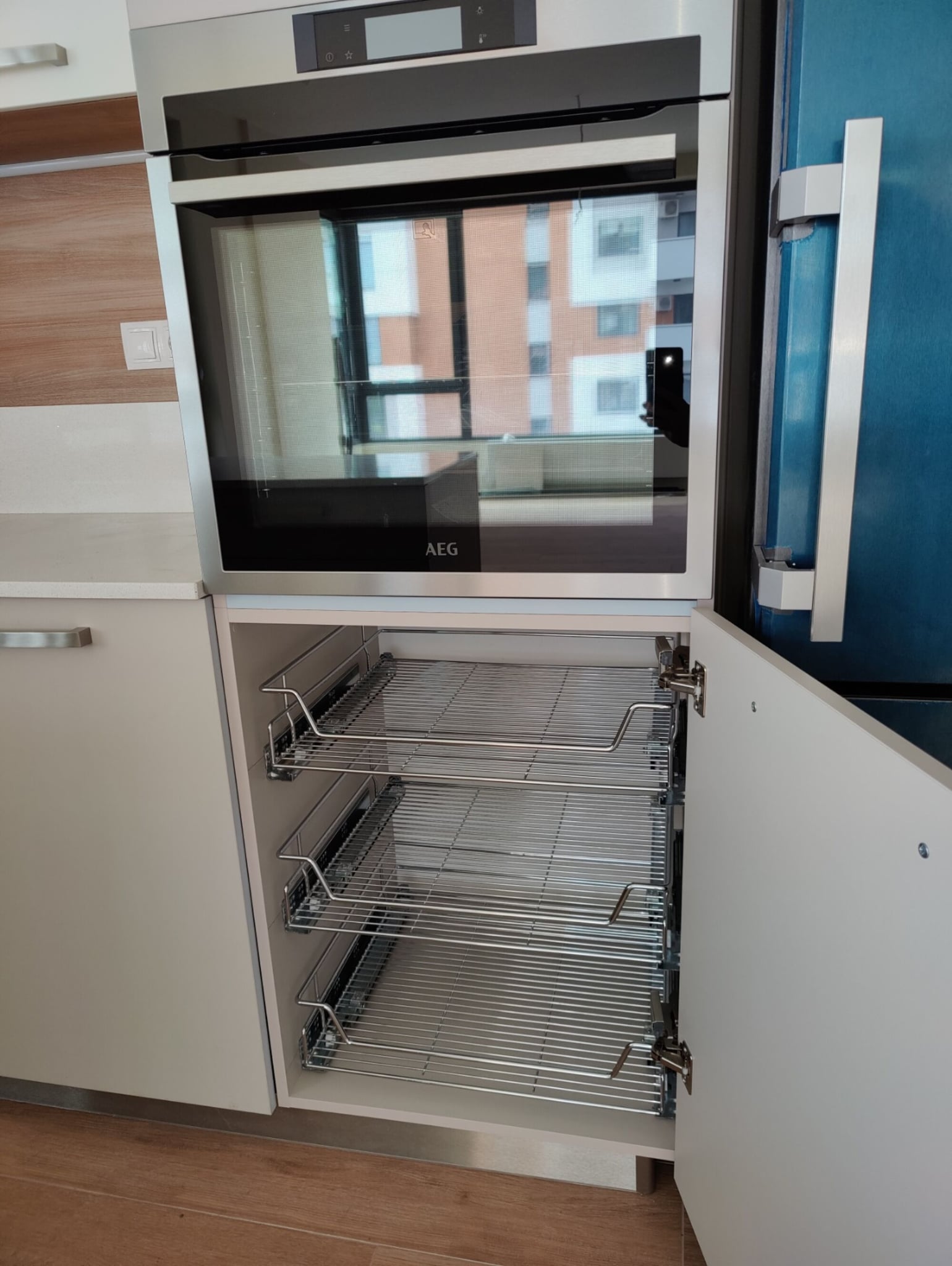 Детайл изтеглящи кошници до фурната – метални рафтове за подредба и плавно затваряне Blum.