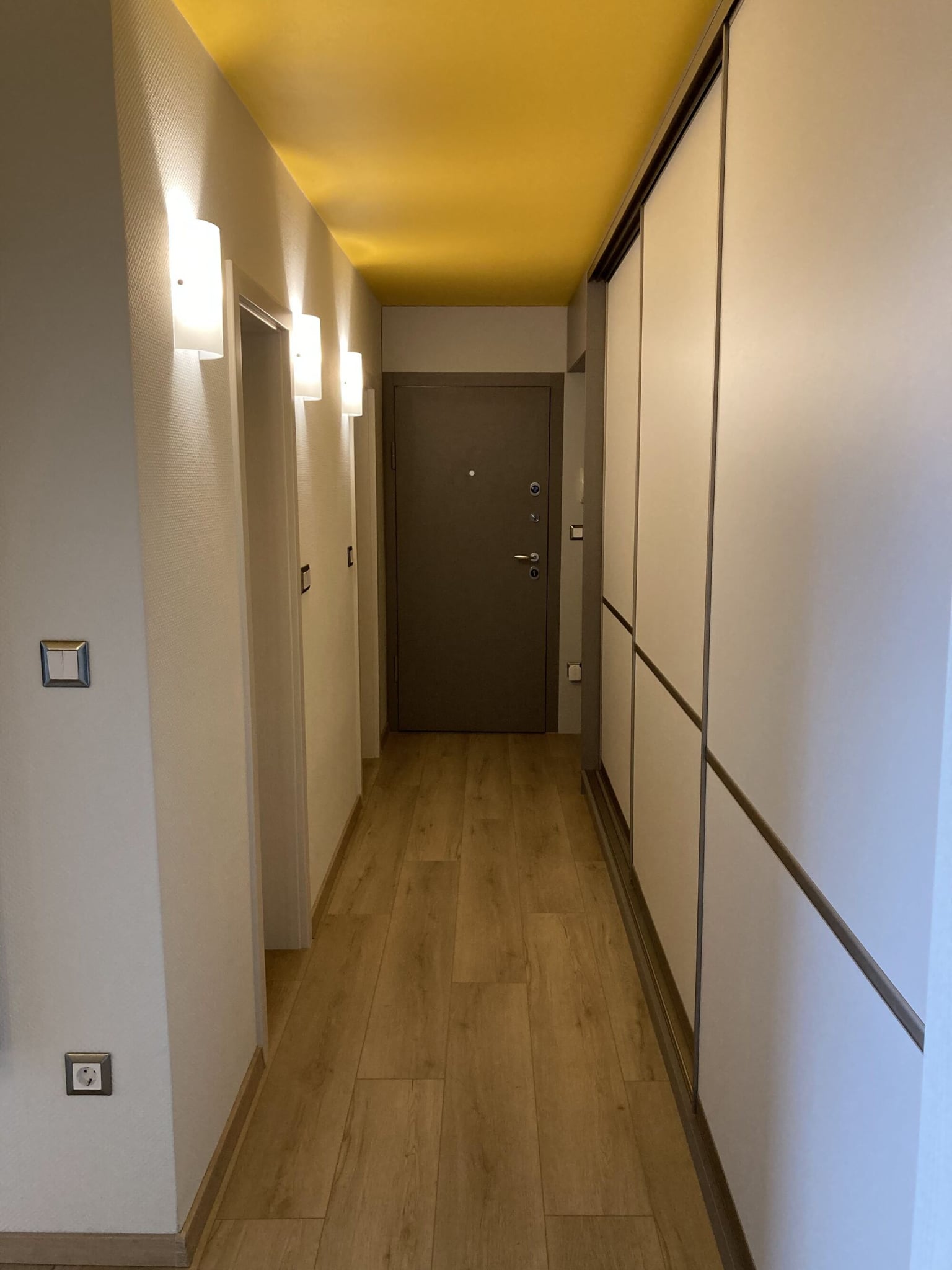 Дискретна линия между антрацит и бяло при плъзгащите врати, подчертаваща геометрията на пространството.