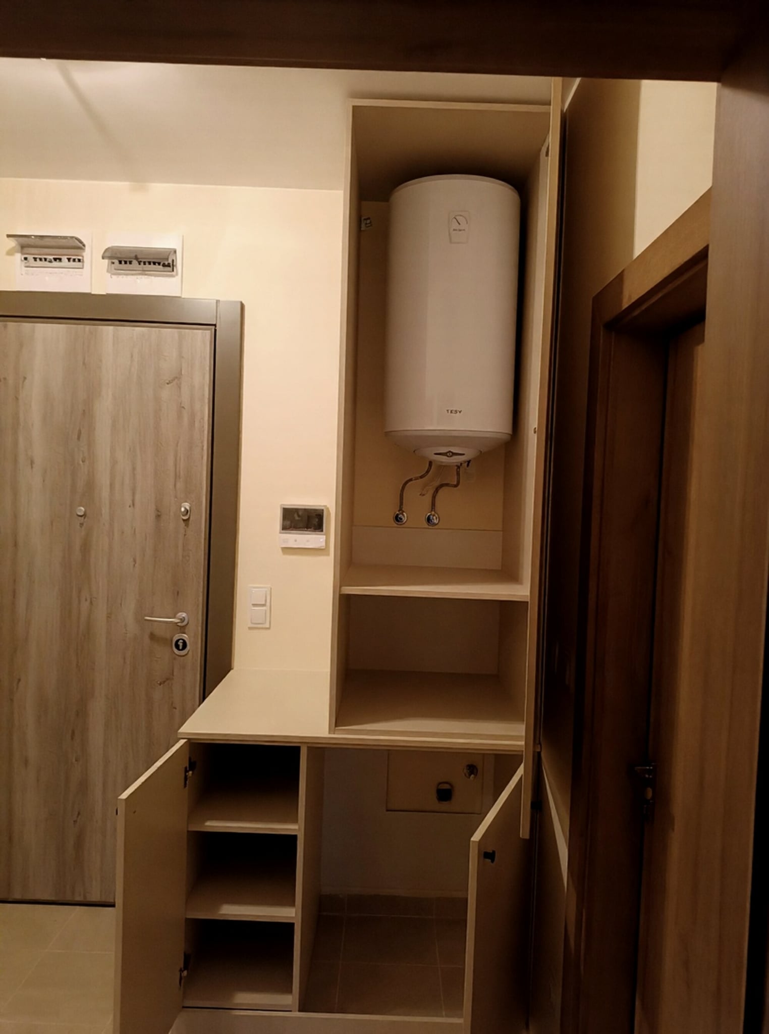 Отворен шкаф с вграден бойлер в коридор, осигурен достъп за обслужване и вентилация
