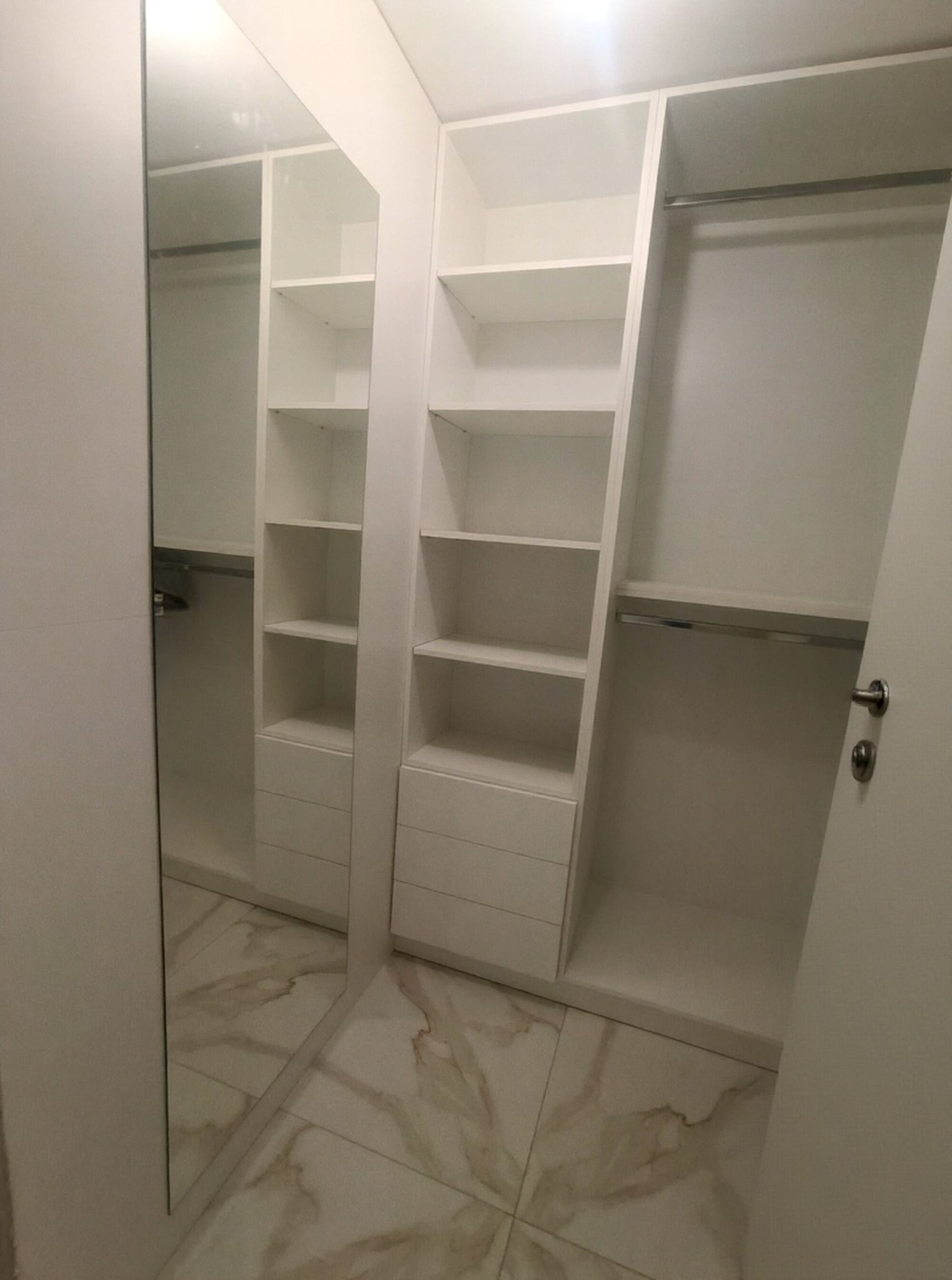 Гардеробна по поръчка в отделно помещение с отворени рафтове, чекмеджета и лостове за закачане. Чист дизайн, максимален ред.