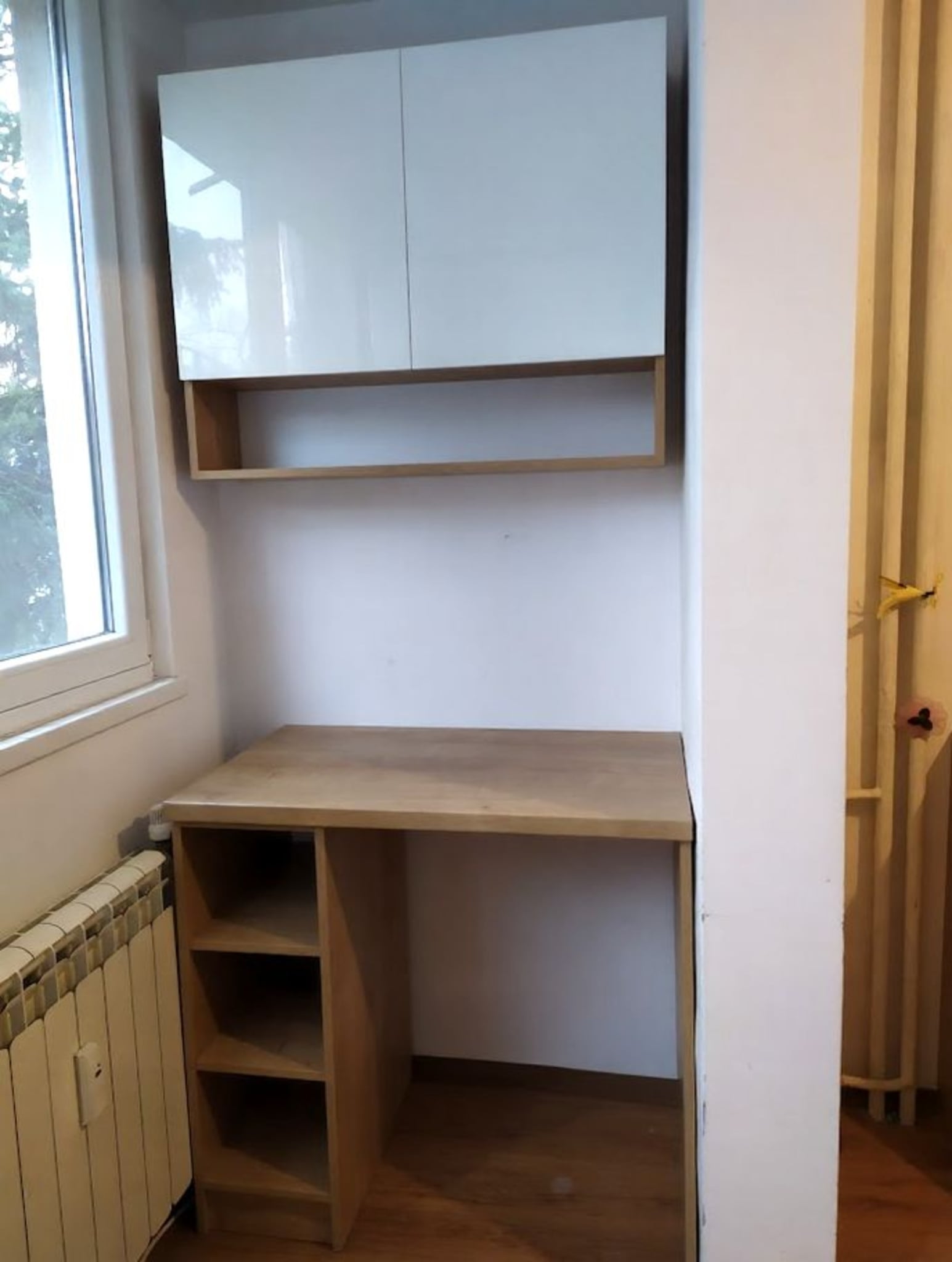 Горен ред шкафове с гланцови бели врати PerfectSense, комбинирани с отворени ниши в дъбов декор за визуална лекота.