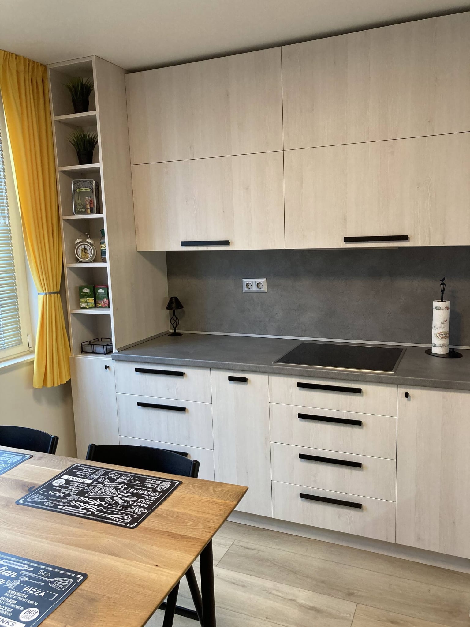 Ъглова работна зона с непрекъснат плот в каменна визия и светъл дървесен декор.