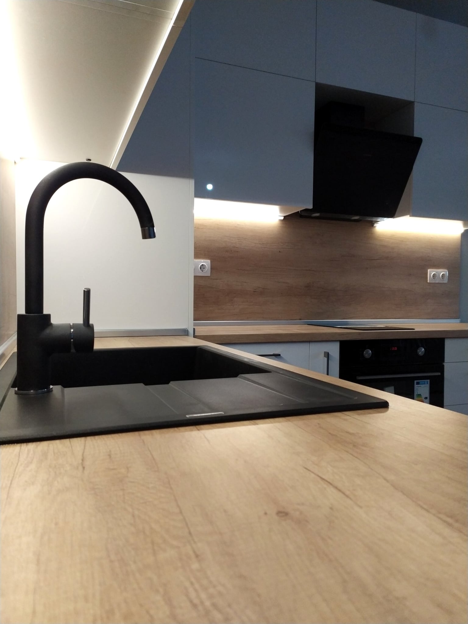 Мивка с черен смесител  с лед осветяване на плота.