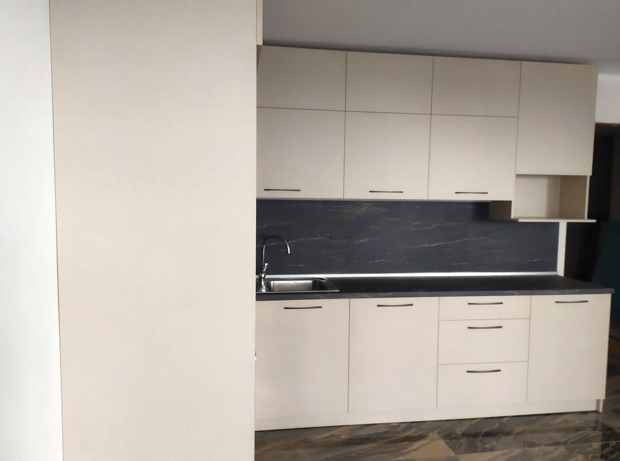 обем с високи горни шкафове до тавана и непрекъсната работна зона.