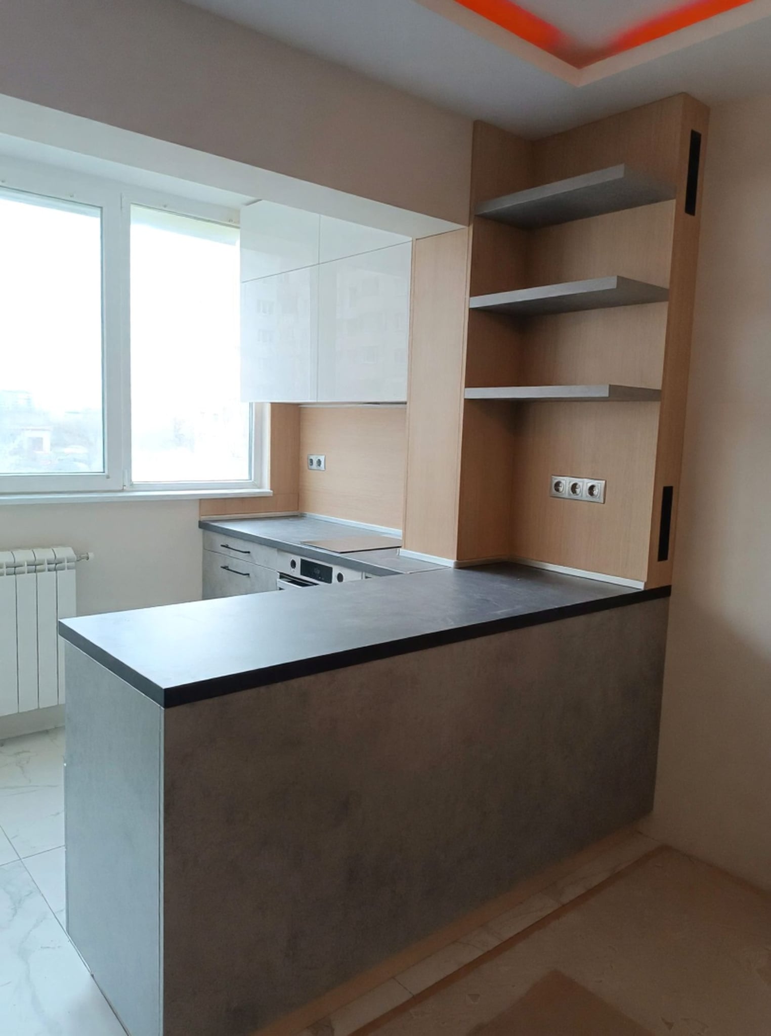 Бар плот с масивен обем и отворени ниши към дневната зона, акцент в бетонен декор F186 S9 и тънък тъмен работен плот.