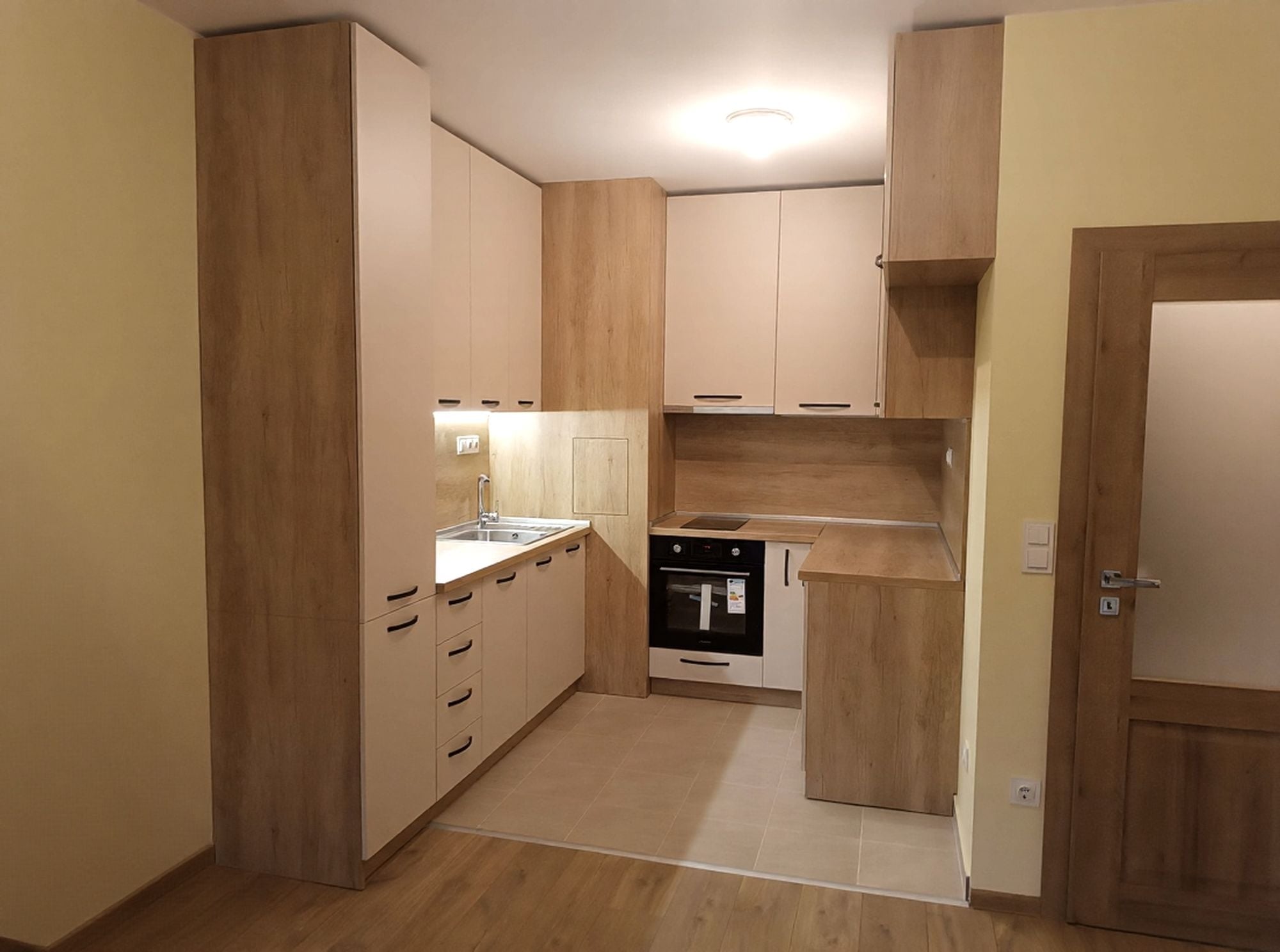 Работен триъгълник с фурна и котлони в ниша, компактно разпределение с топъл дървесен плот