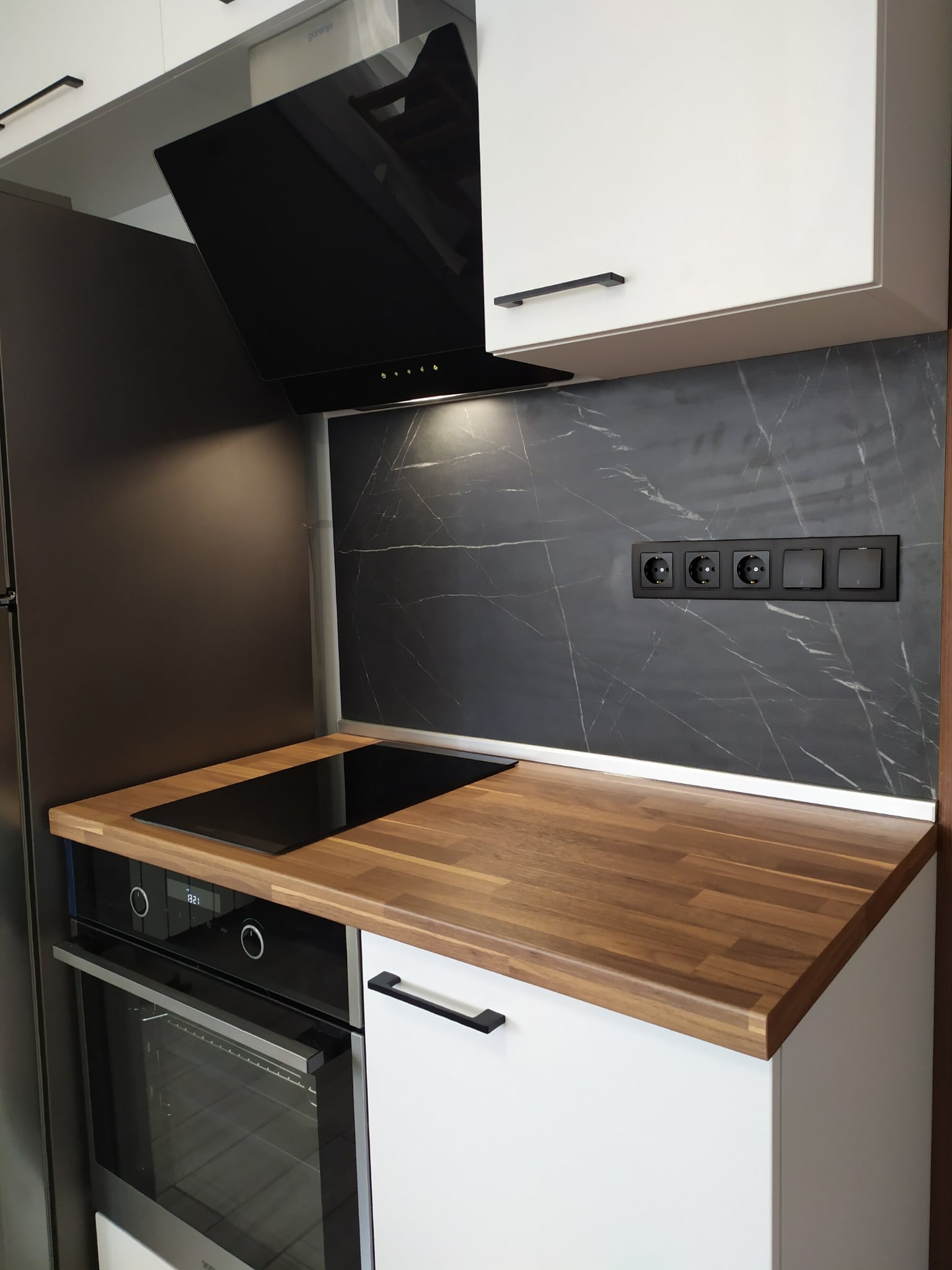 Зона с фурна и котлони под черен стъклен абсорбатор и контрастен гръб с мраморна структура F206 ST9