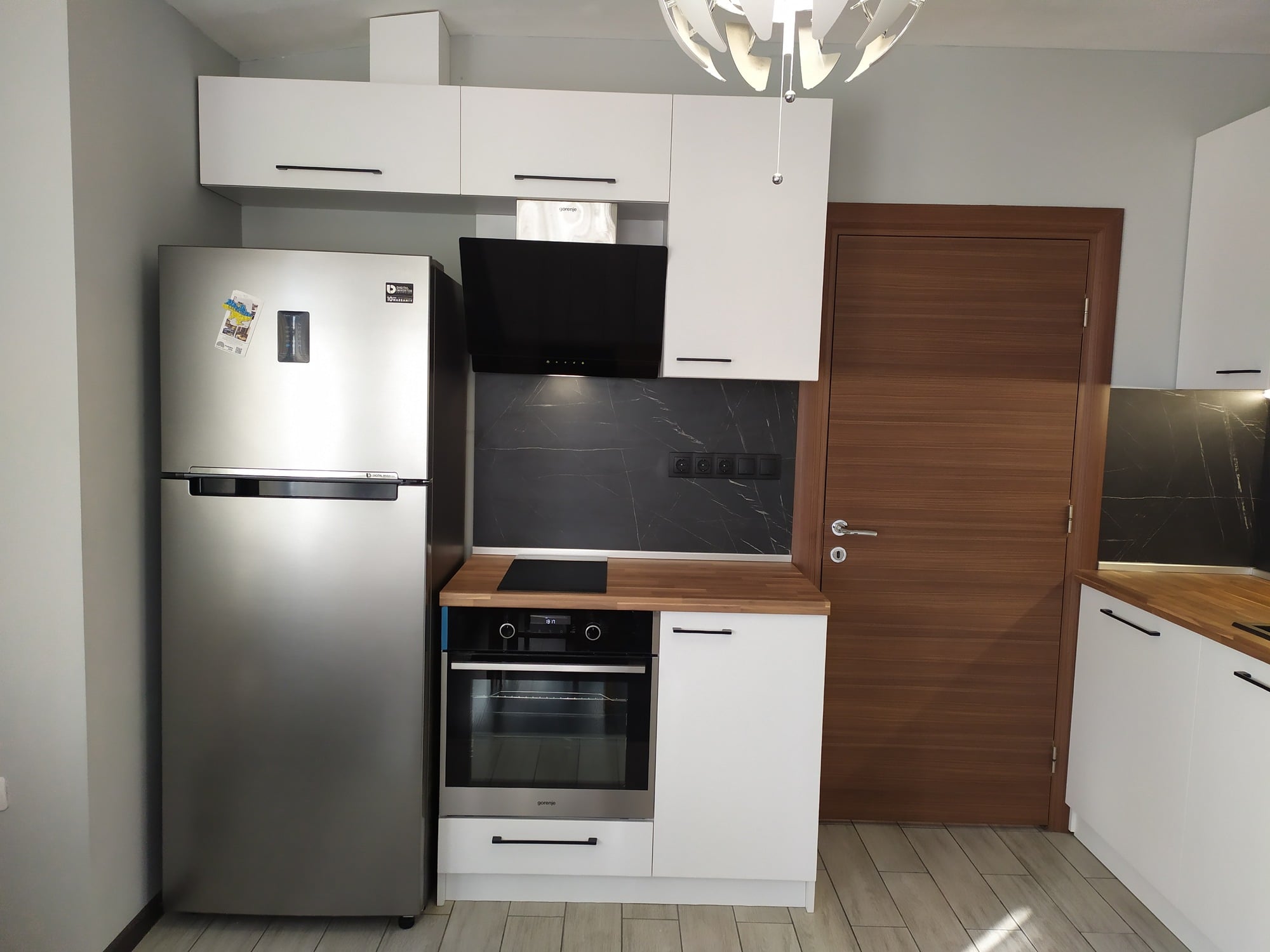 Работен кът с LED осветление под горните шкафове и непрекъсната линия на графитения гръб