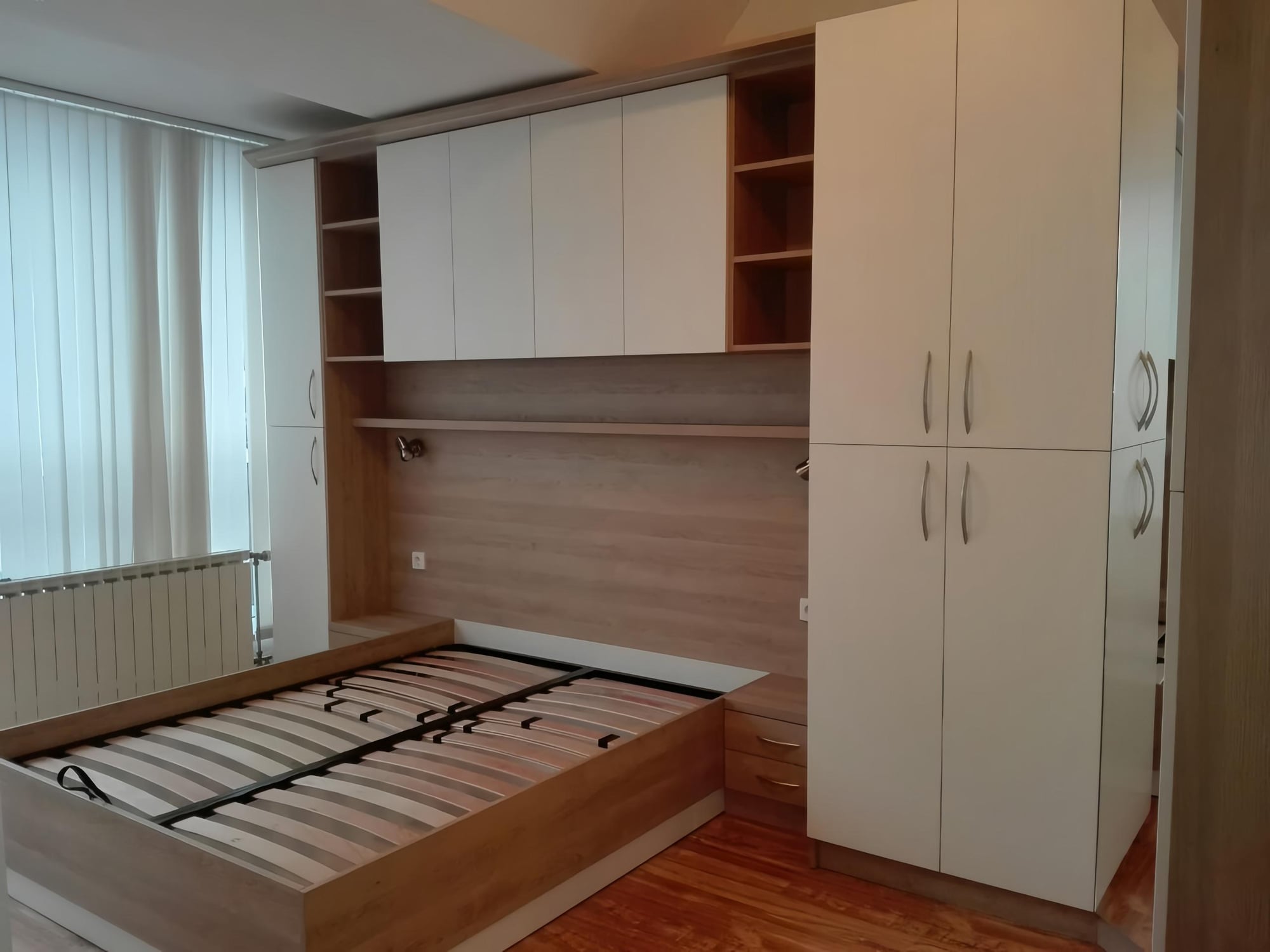 Горни шкафове над леглото с вградено LED осветление и отворени ниши в дървесен декор