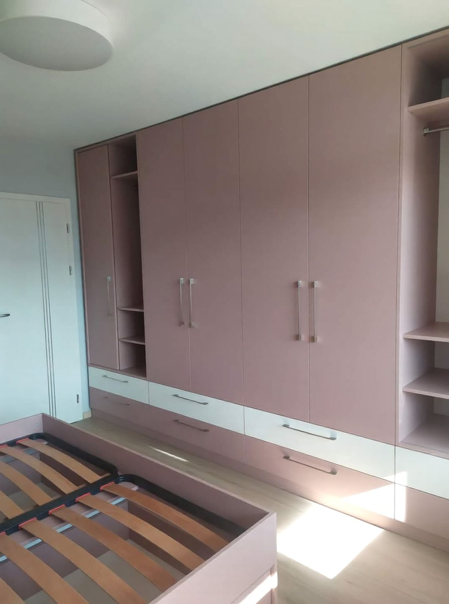 Гардероб по поръчка в цвят антична роза, с плъзгащи врати и чекмеджета.