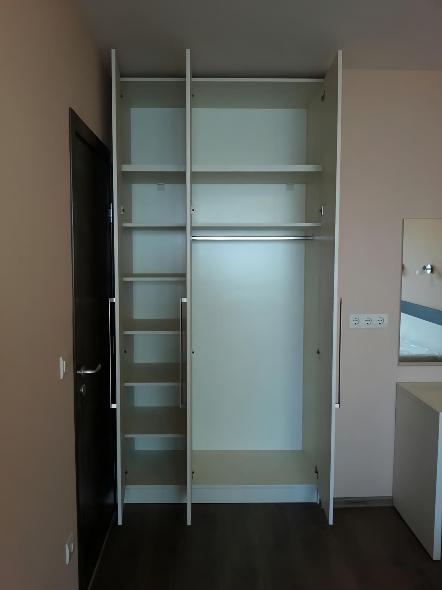 Вътрешно разпределение на гардероб с рафтове и лост за дрехи.