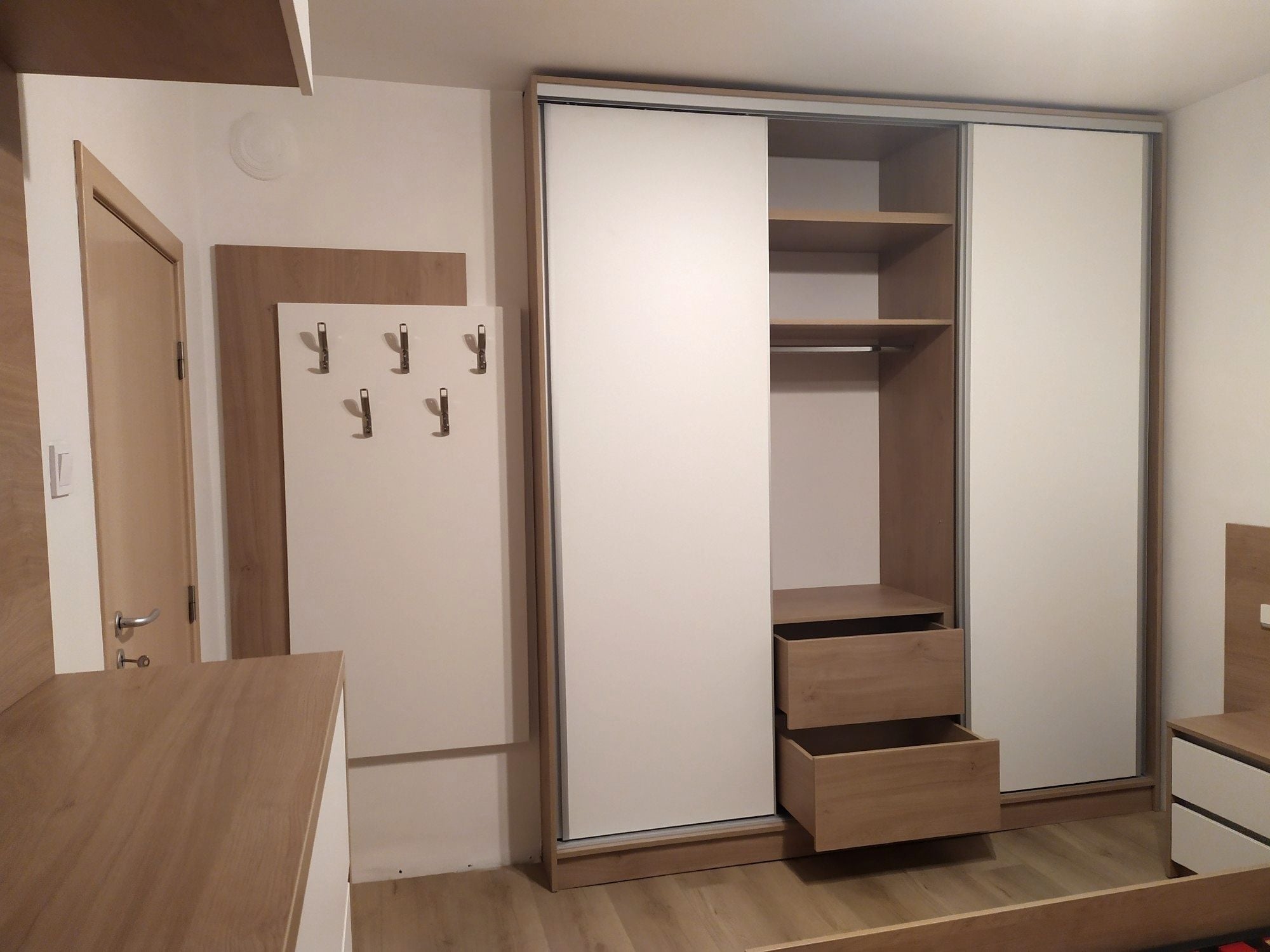 гардероб с алуминиев профил и комбинация от бяло и дървесен декор.