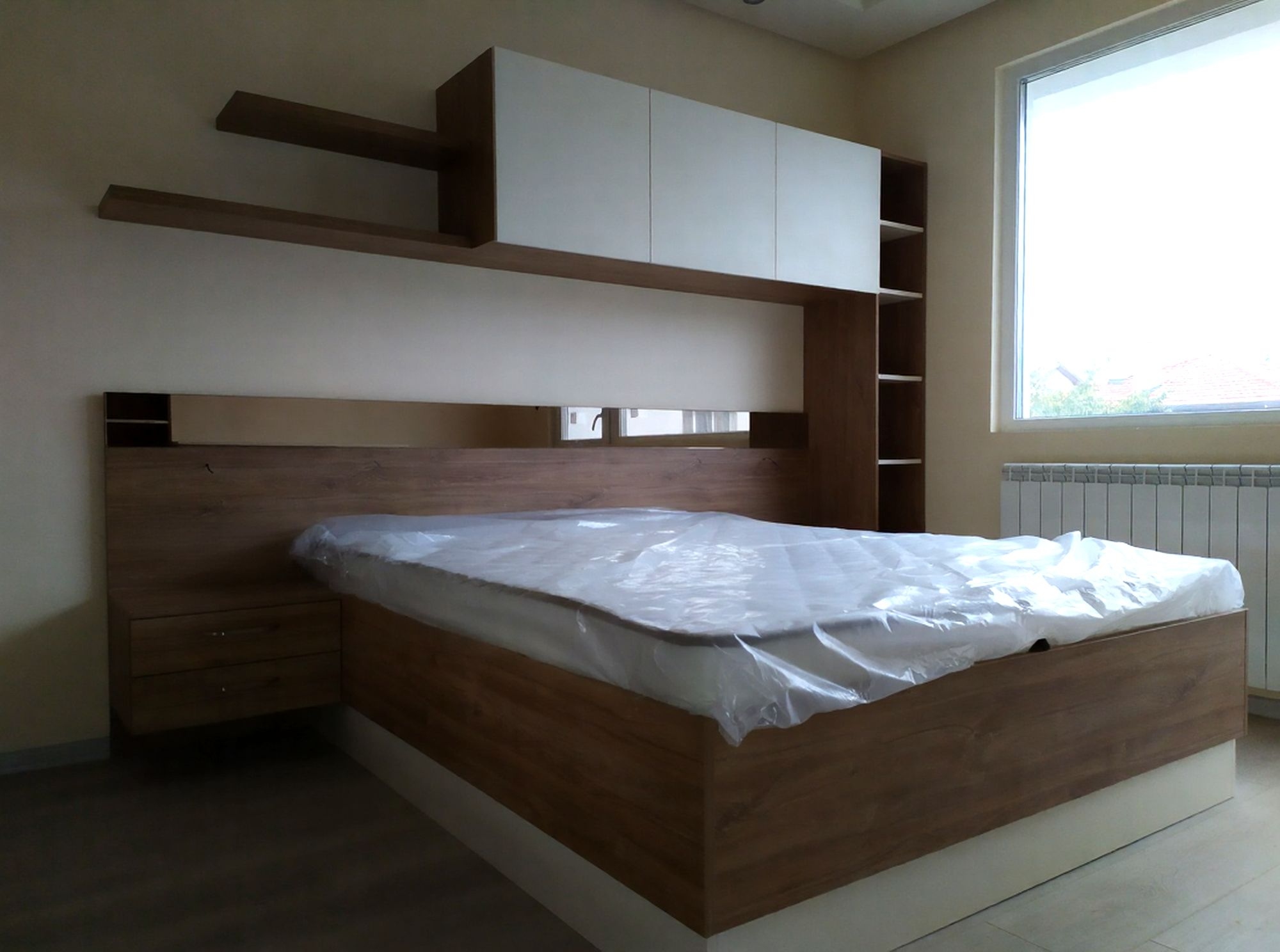 Спалня по поръчка с гардероб с плъзгащи врати и огледало, легло с табла и работен кът. Комбинация от U216 ST9 Каме и H1113 ST10 Дъб Канзас EGGER – функционално решение с много място за съхранение и модерен дизайн.