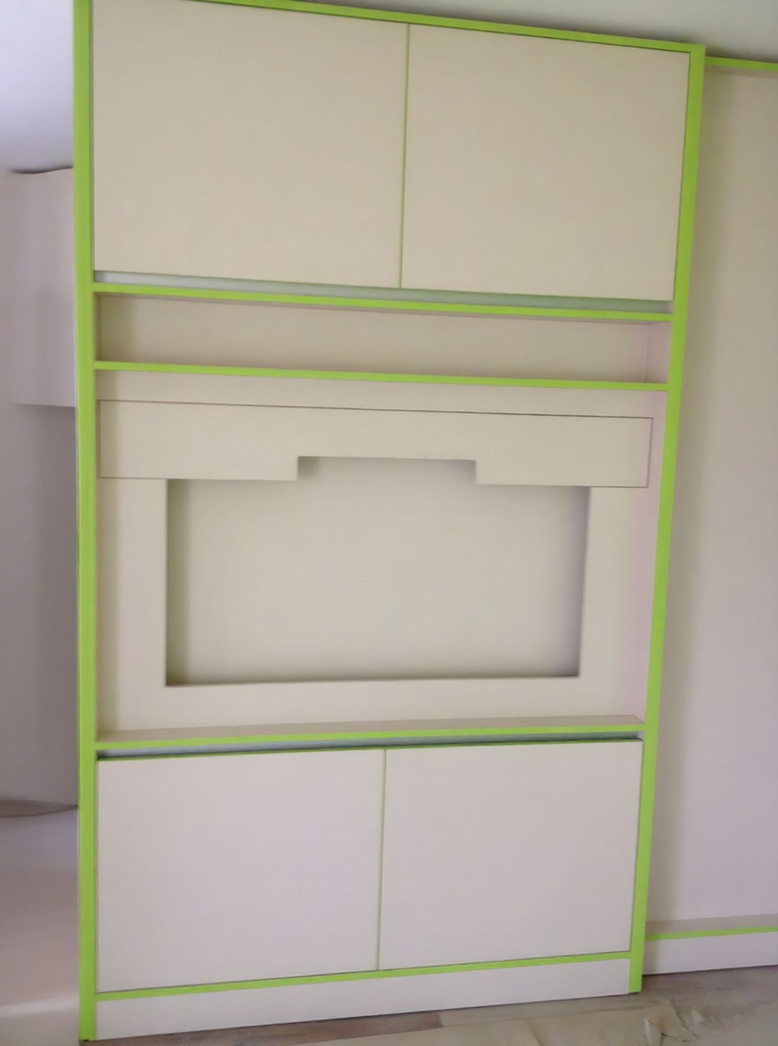 Детайл на TV модул с ниши и шкафове, обрамчени със зелени акцентни линии.