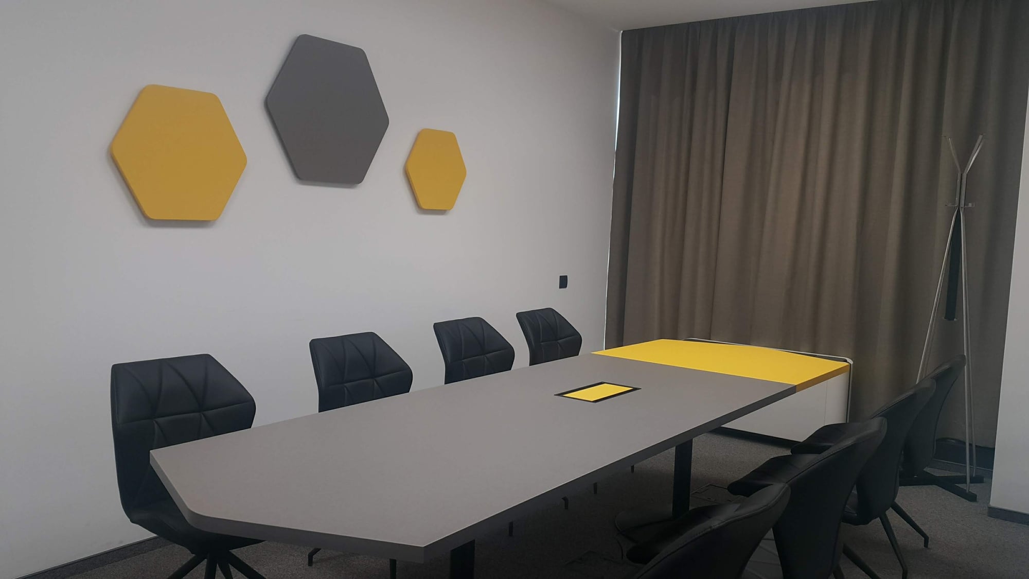 Ъглова модерна кухня по поръчка със светли гланцови шкафове, плот светъл дъб, черни дръжки и LED осветление.