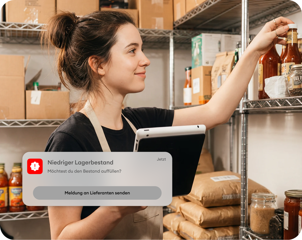 Viele Menschen in einem großen, hellen Raum mit hohen Fenstern und einem großen Bildschirm an der Wand bei einer Veranstaltung oder einem Treffen.