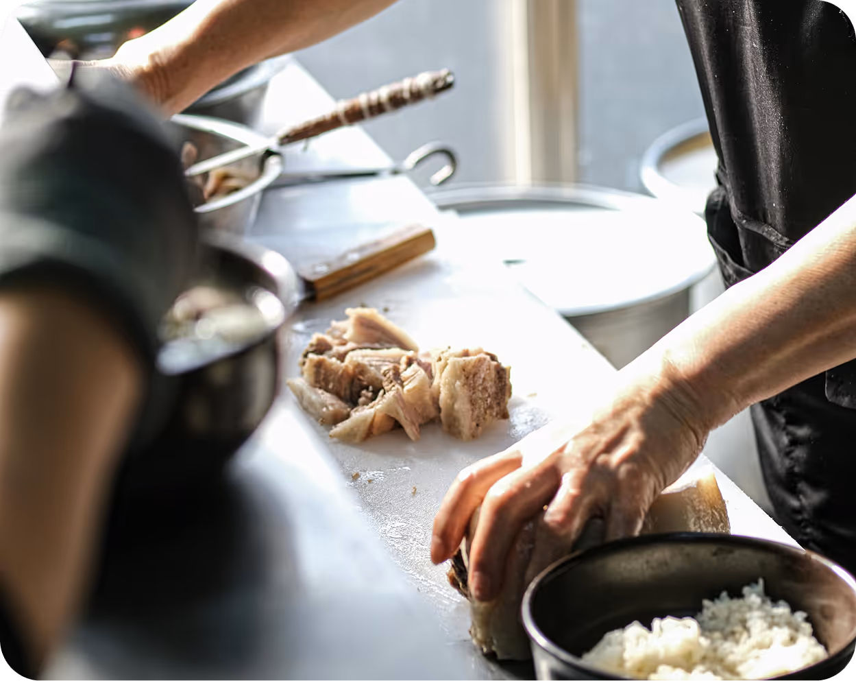 Viele Menschen in einem großen, hellen Raum mit hohen Fenstern und einem großen Bildschirm an der Wand bei einer Veranstaltung oder einem Treffen.