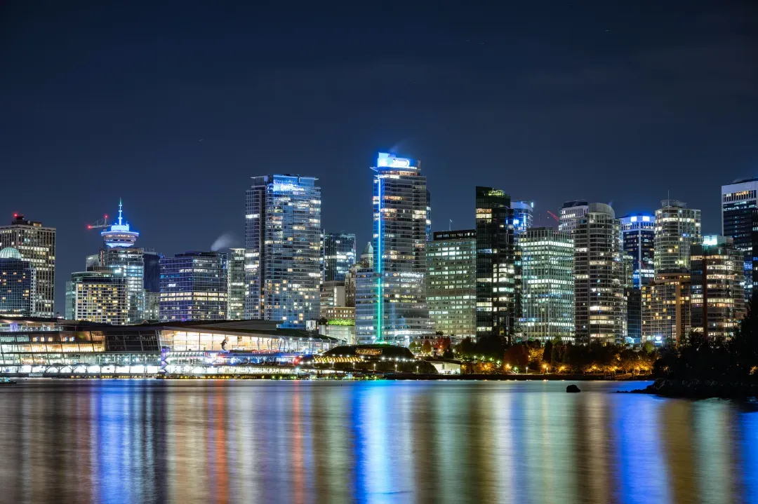 Beautiful night view of Vancouver's illuminated skyline reflecting on the water.