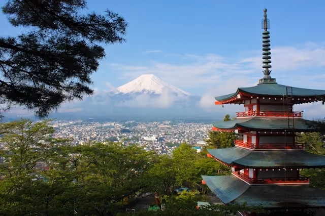 Red pagoda overlooking Kyoto, Japan, with the city and mountains in the distance