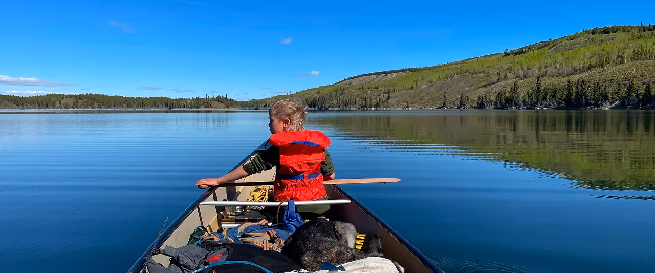 A child in a canoe on a beautiful lake in Yukon, thanks to the WILDE Way Bursary Fund