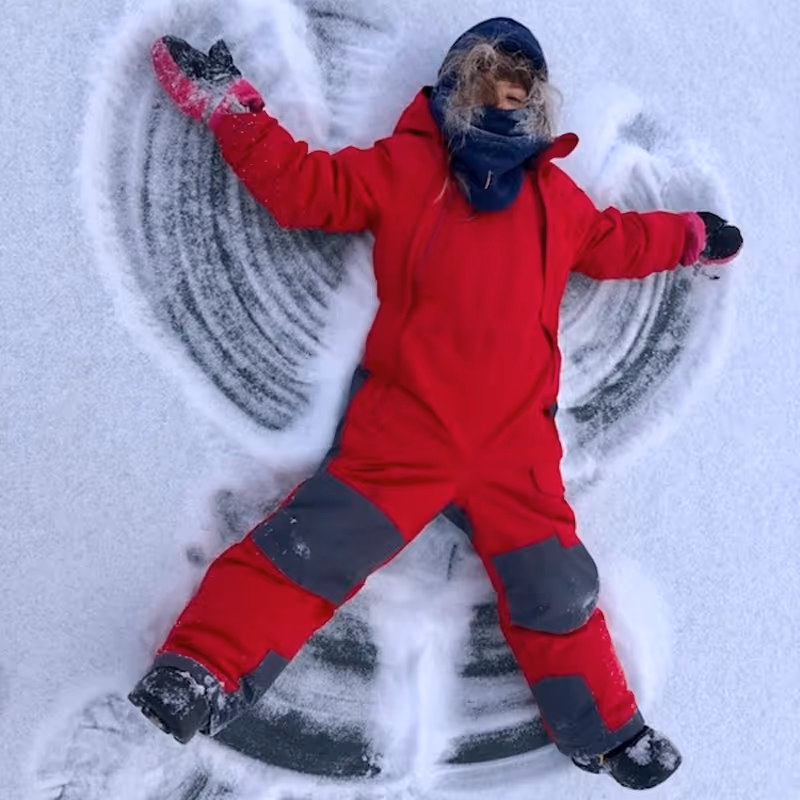Child in a snowsuit making a snow angel thanks to the WILDE School Champion Fund