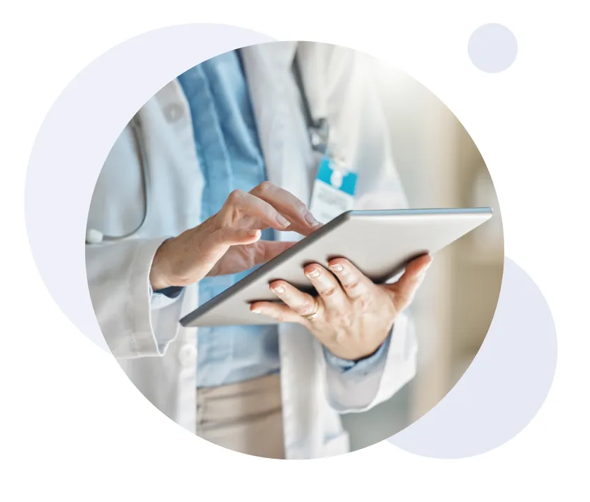 Profesional sanitario con bata blanca utilizando una tableta.