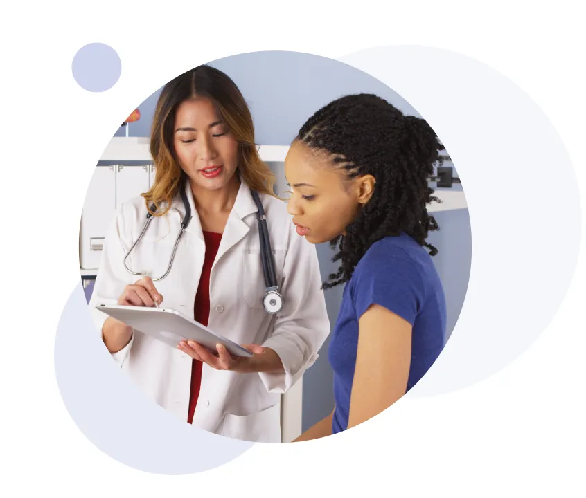 Mujer médico mostrando información en una tableta a un paciente en una consulta médica.