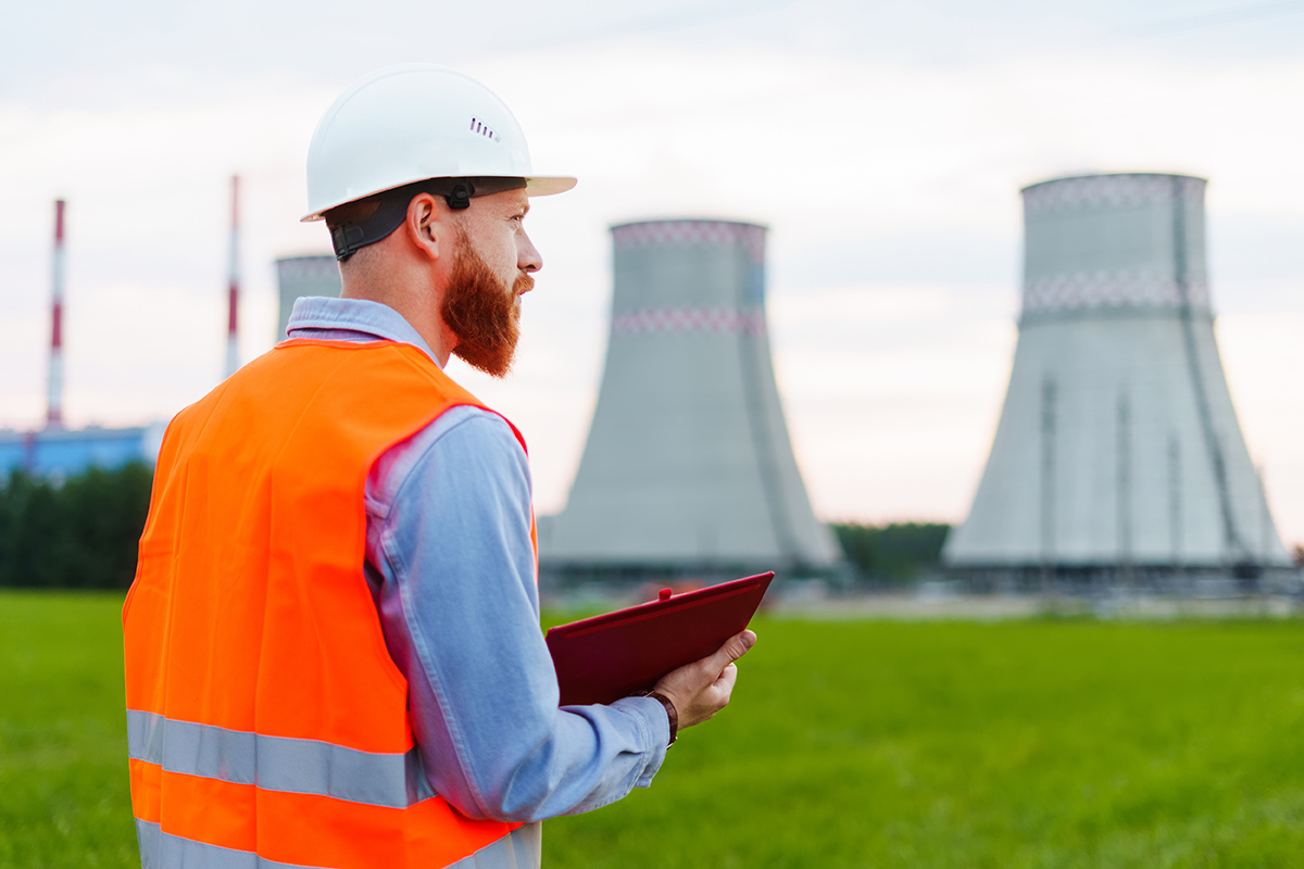 An engineer with a notebook on the background of a power plant. 