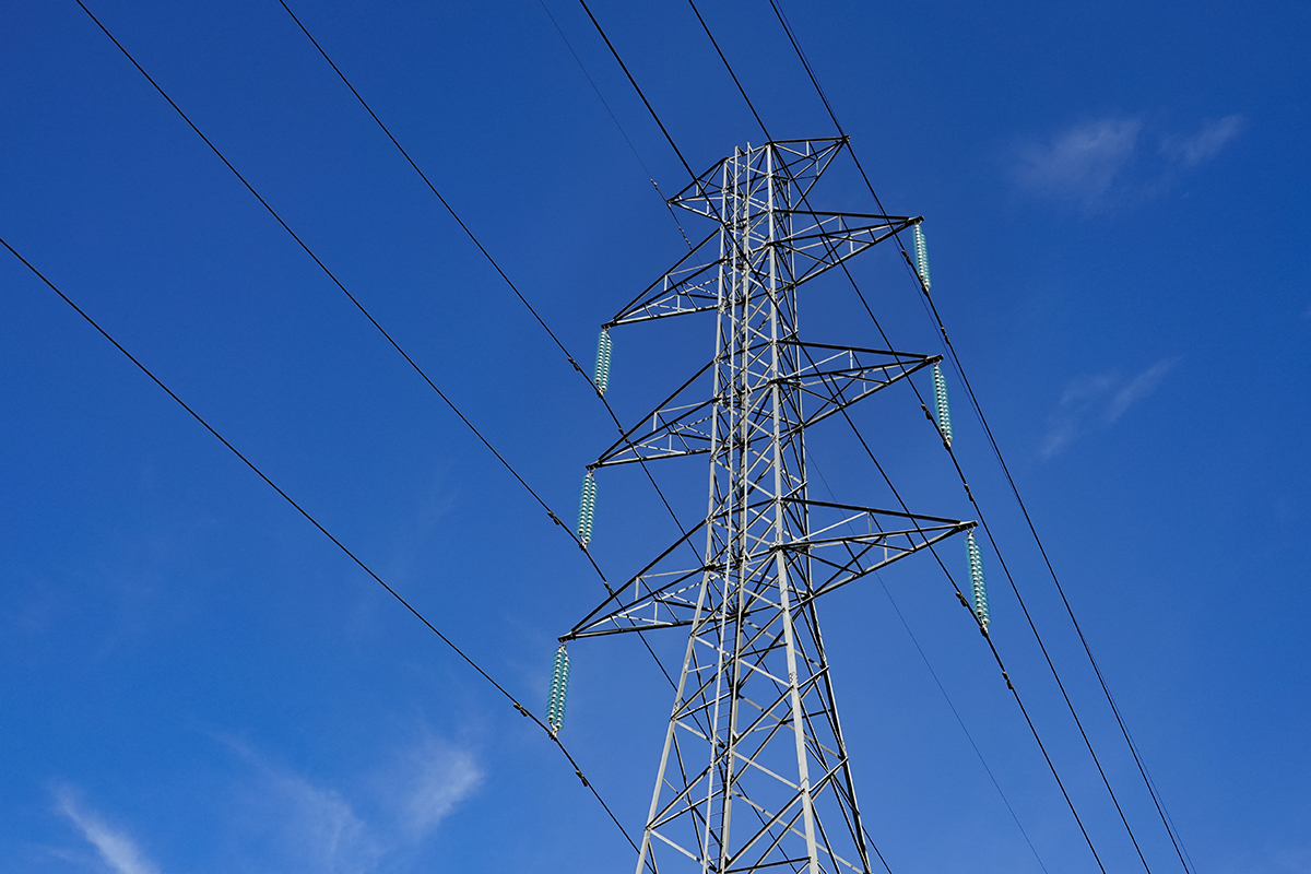transmission lines under a clear blue sky.
