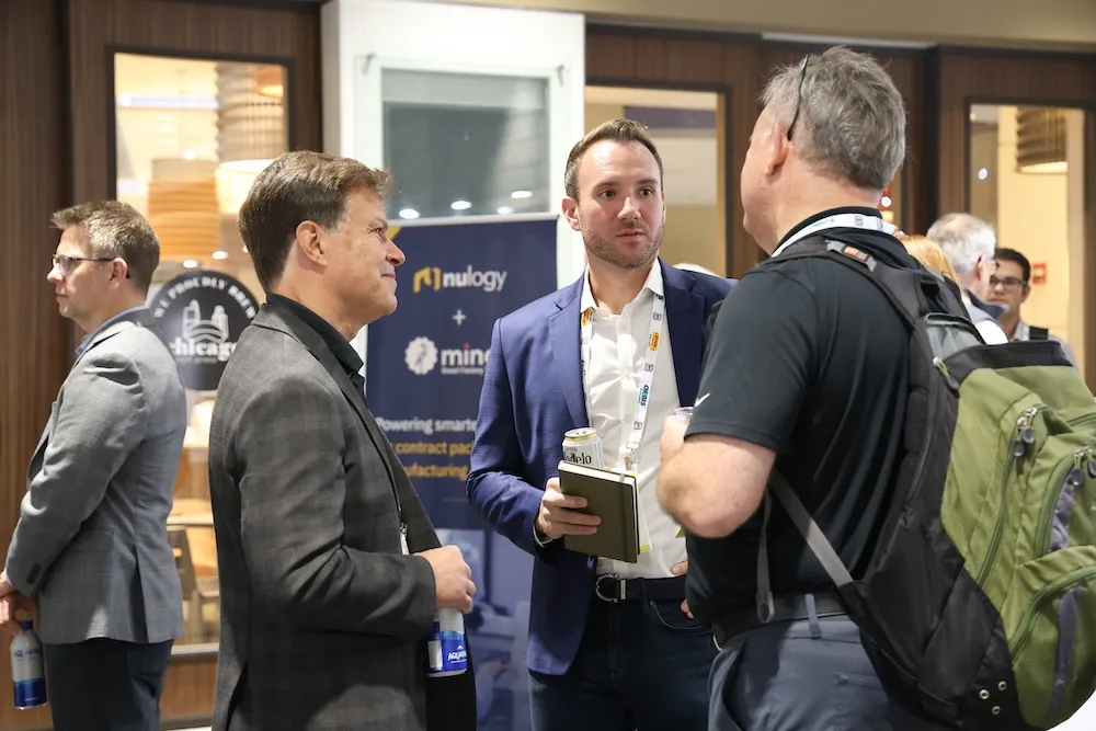 Three men engaged in conversation at a professional event.