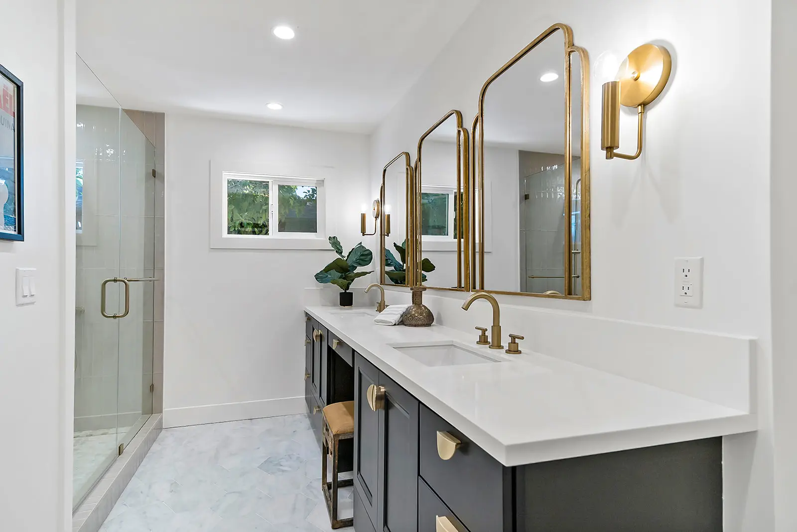 Custom master bathroom by Enhaus Design & Build, featuring a light oak floating double vanity with a quartz countertop, minimalist brass fixtures, and large twin rectangular mirrors.