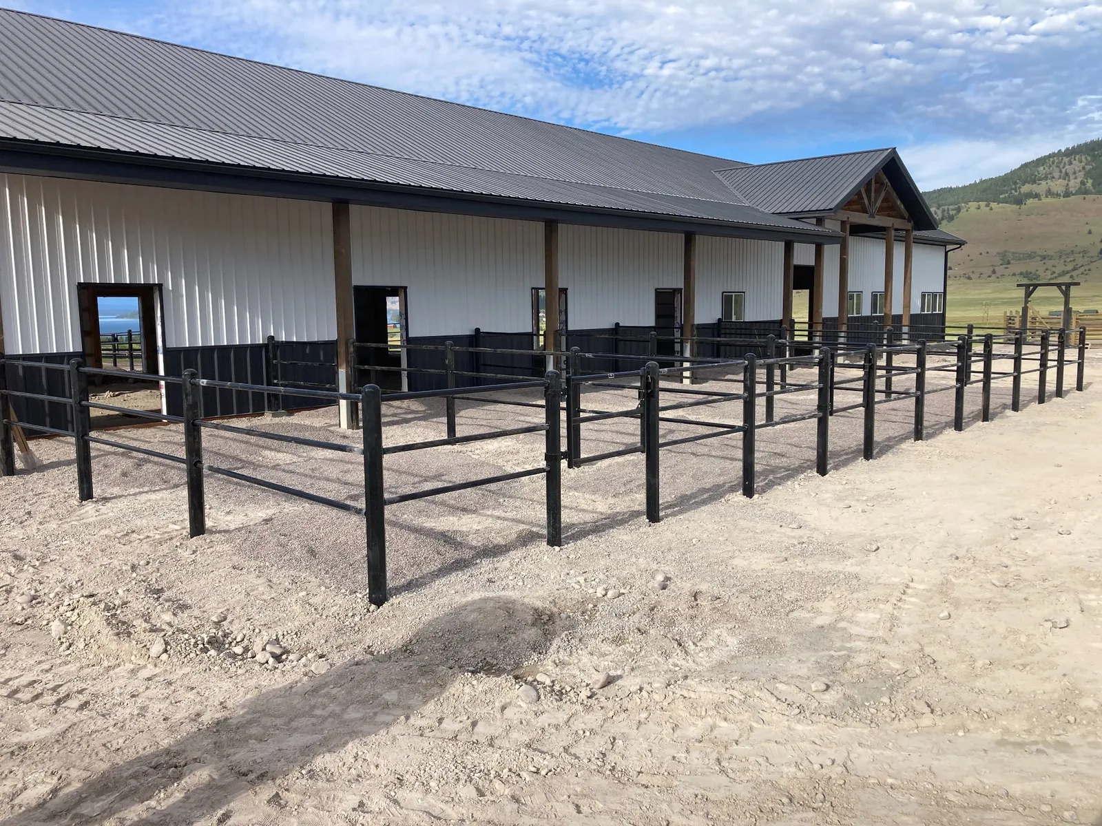 Black Priefert Estate Fence paddock installation beside an existing barn in Montana