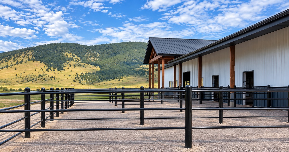 Modern ranch property with black rail fencing and a contemporary barn