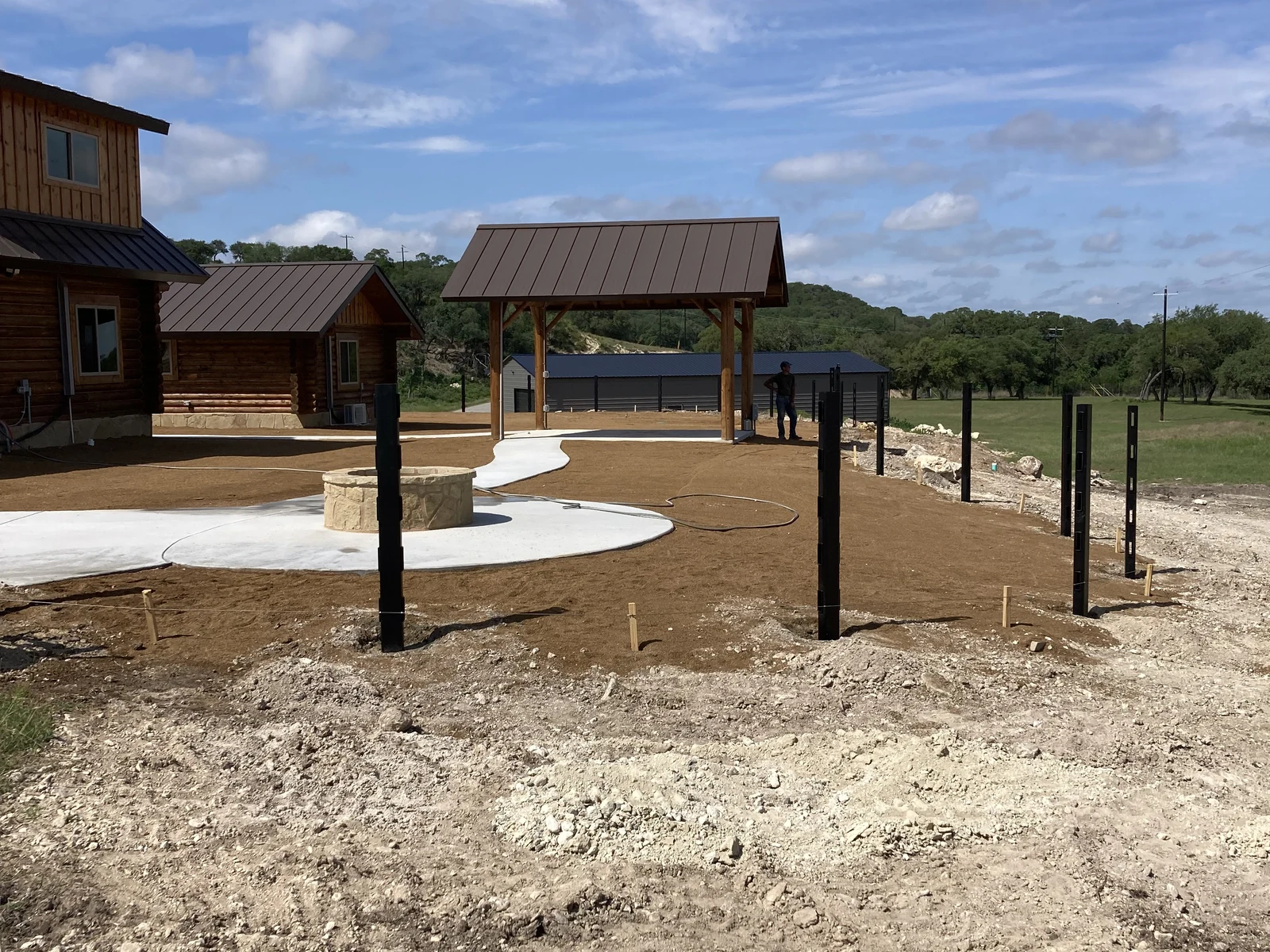 Fence posts laid out around the cabin patio during construction
