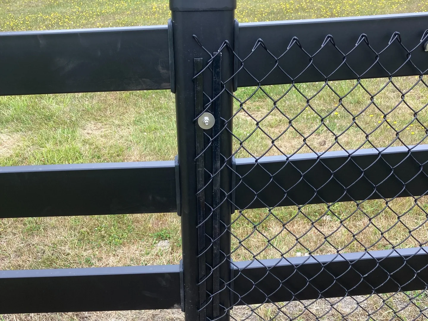 Close detail of the chain-link connection to Buckley Steel Board fencing on San Juan Island