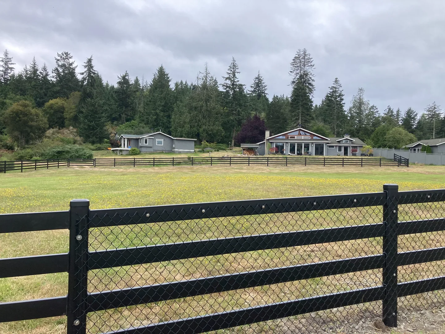 Wide estate overview with black Buckley Steel Board fence on San Juan Island