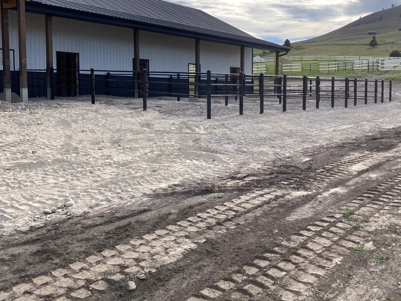 Long perspective along black Priefert Estate Fence paddocks in Big Arm, Montana