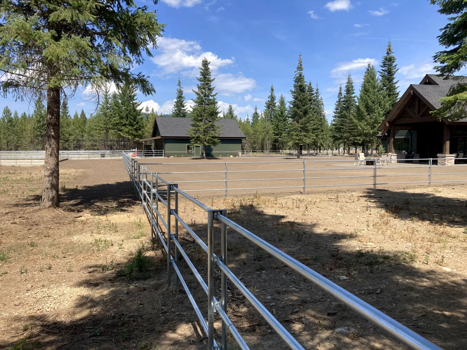 Pasture fence toward house at the Hayden, Idaho Dream Ranch project