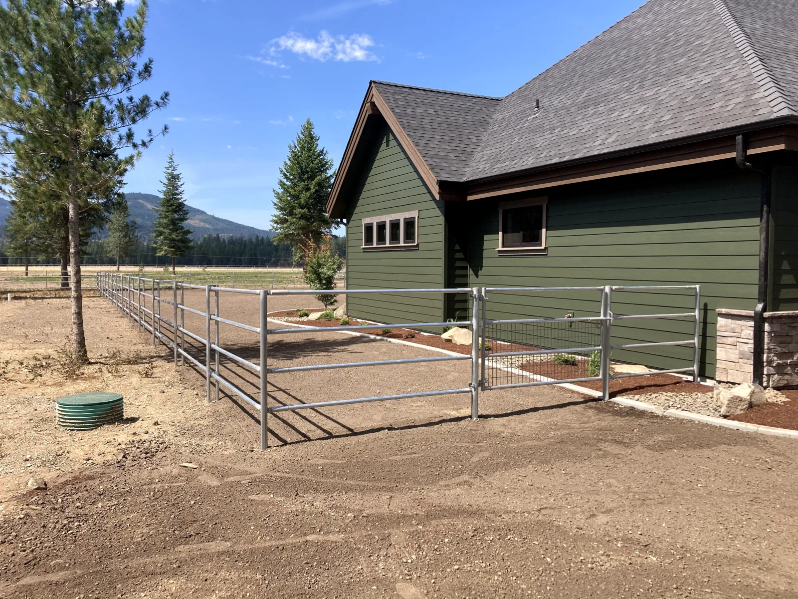 House and mesh gate at the Hayden, Idaho Dream Ranch project