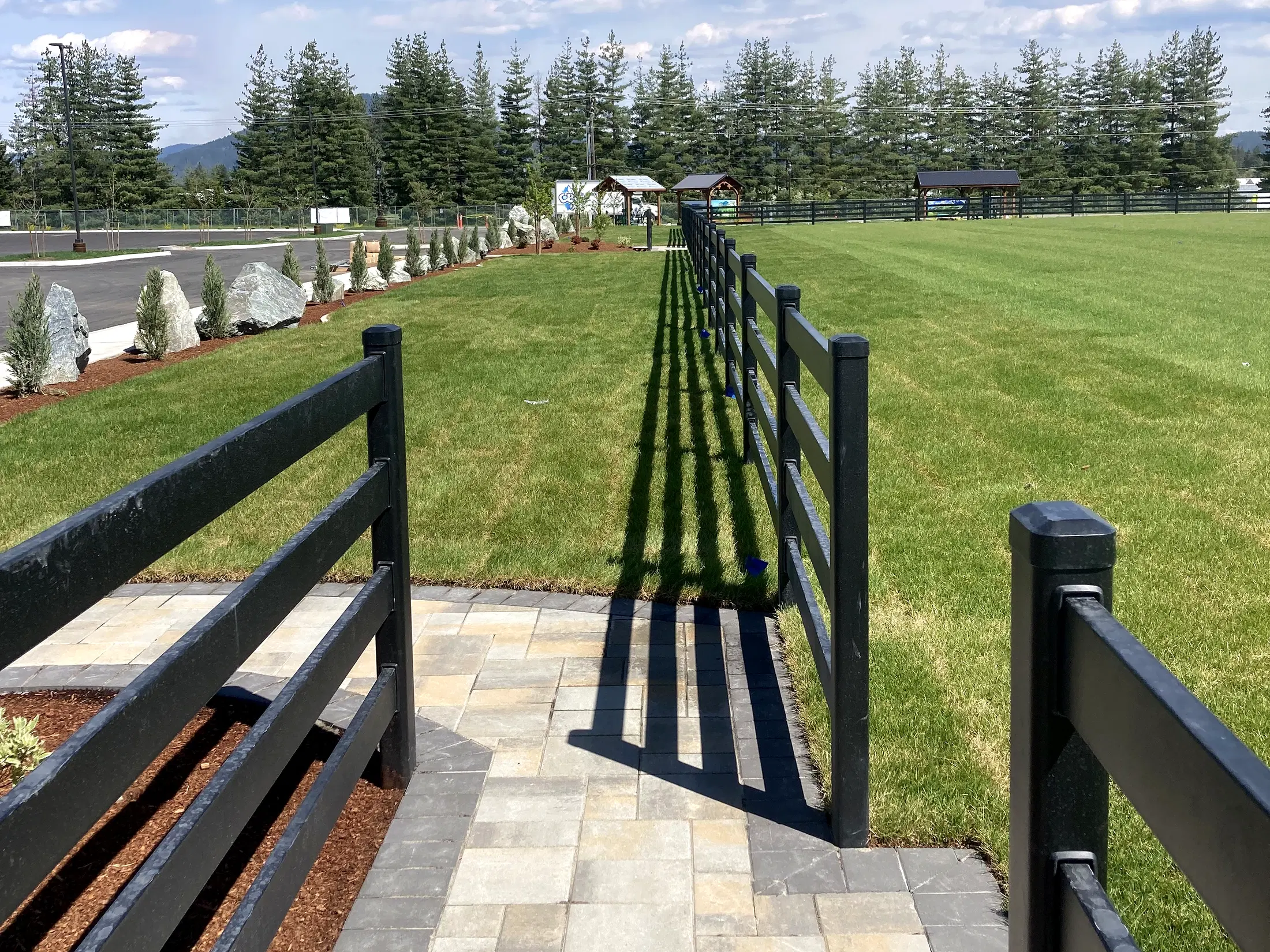Open ball-field entry with paver transition at Faith Walk Community Fitness Park in Coeur d'Alene, Idaho