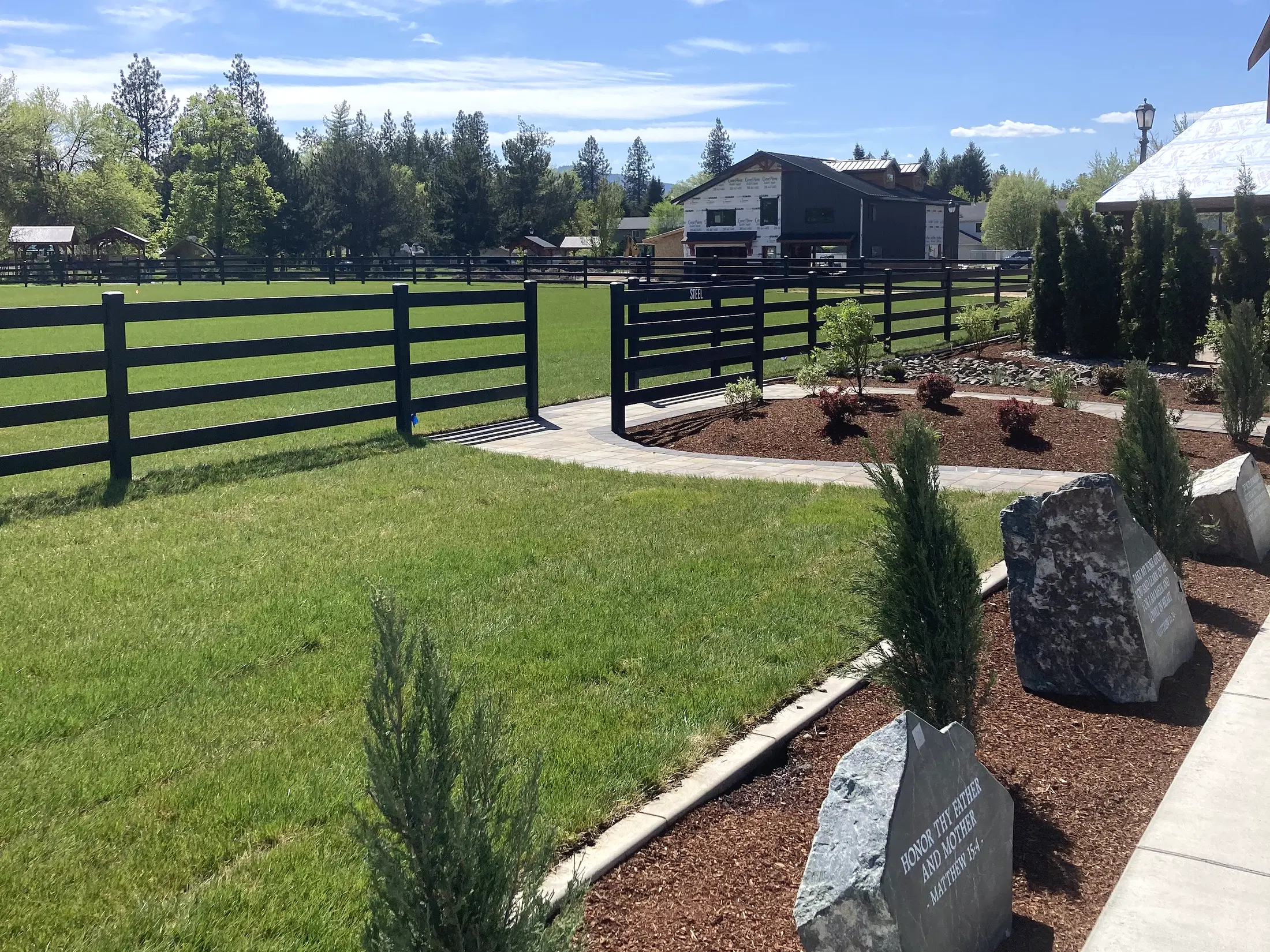 Fence along landscaped walkway at Faith Walk Community Fitness Park in Coeur d'Alene, Idaho
